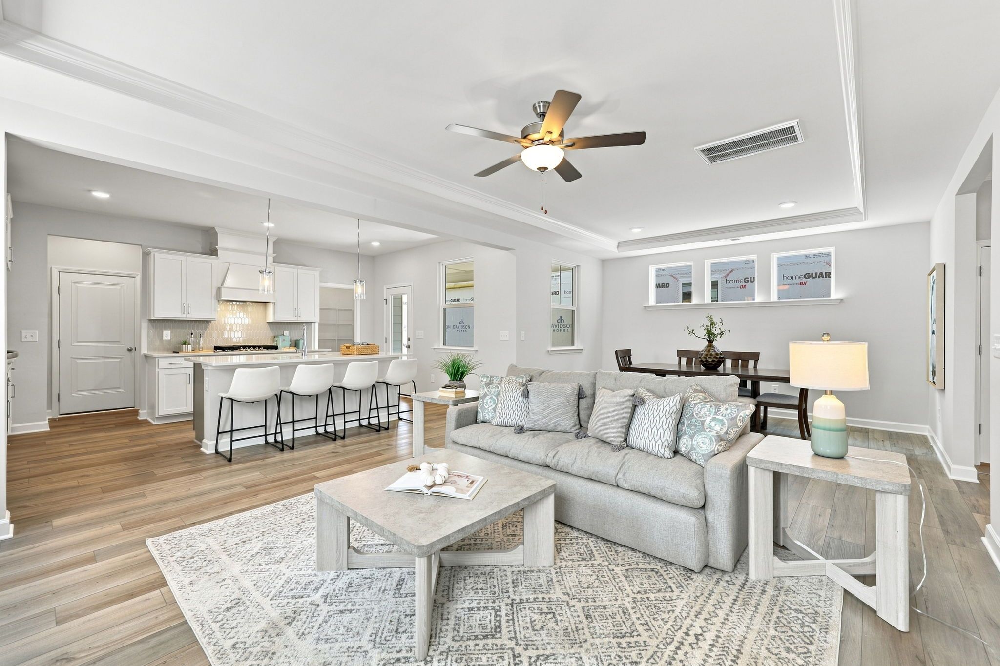 Open-concept living room and kitchen in The Jordan A by Davidson Homes featuring a large island and modern interior design.