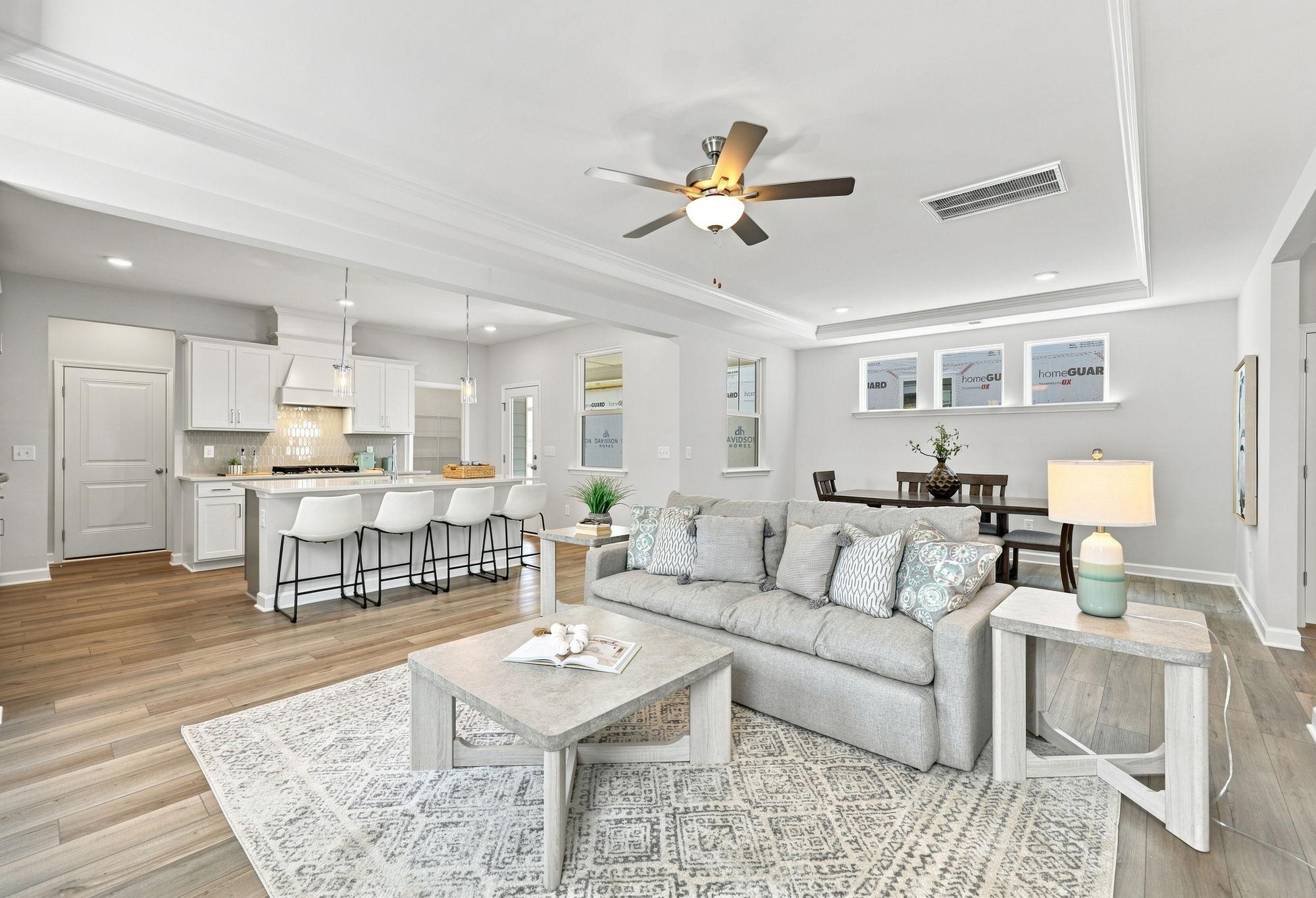 Open-concept living room and kitchen in The Jordan A by Davidson Homes featuring a large island and modern interior design.
