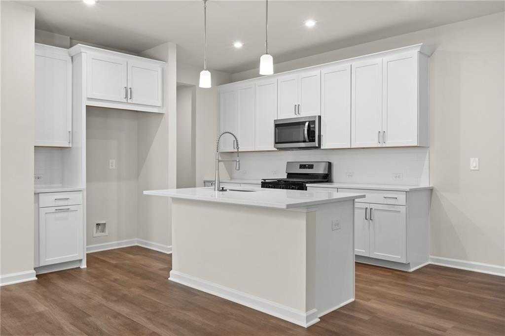 Bright modern kitchen with white shaker cabinets, quartz island, stainless appliances in The Marion B by Davidson Homes, Kennesaw GA