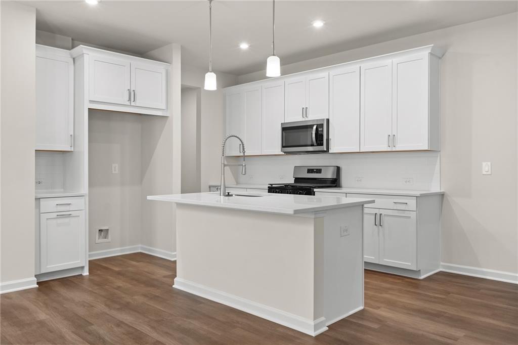 Bright modern kitchen with white shaker cabinets, quartz island, stainless appliances in The Marion B by Davidson Homes, Kennesaw GA