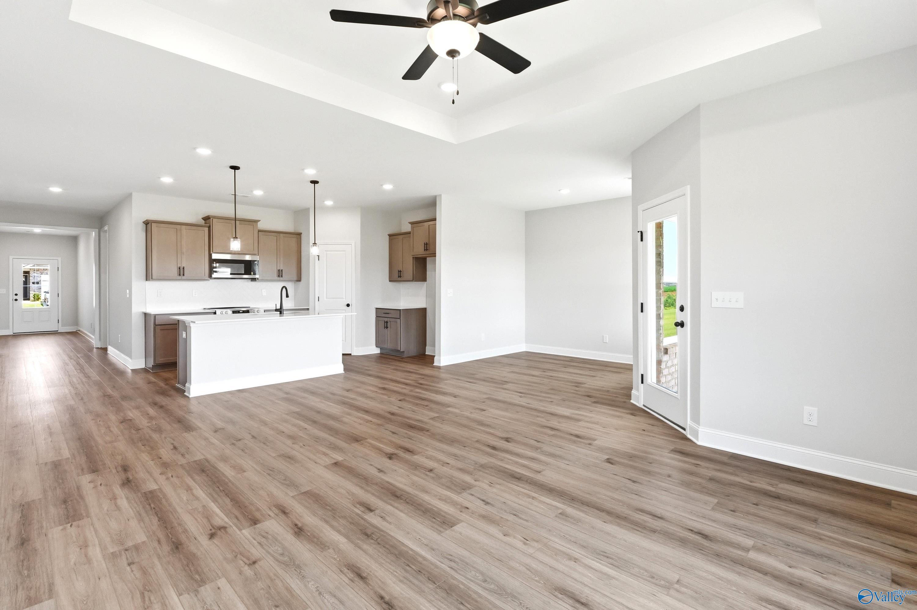 Open-concept living room and kitchen with tray ceiling in The Daphne floor plan by Davidson Homes, Clearview, Hazel Green.