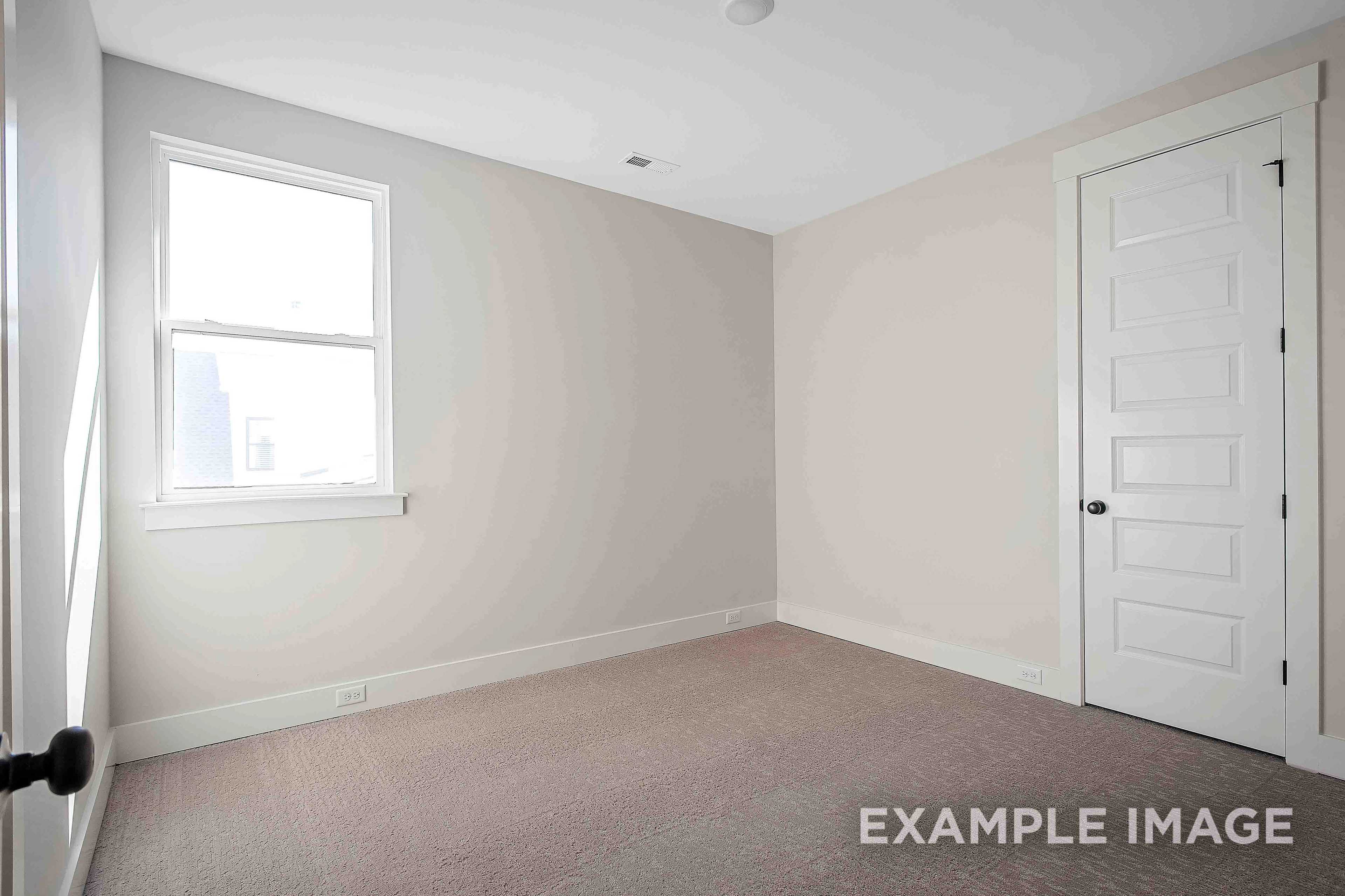 Spacious empty master bedroom in The Alston A featuring beige walls, large window, and carpeted floor