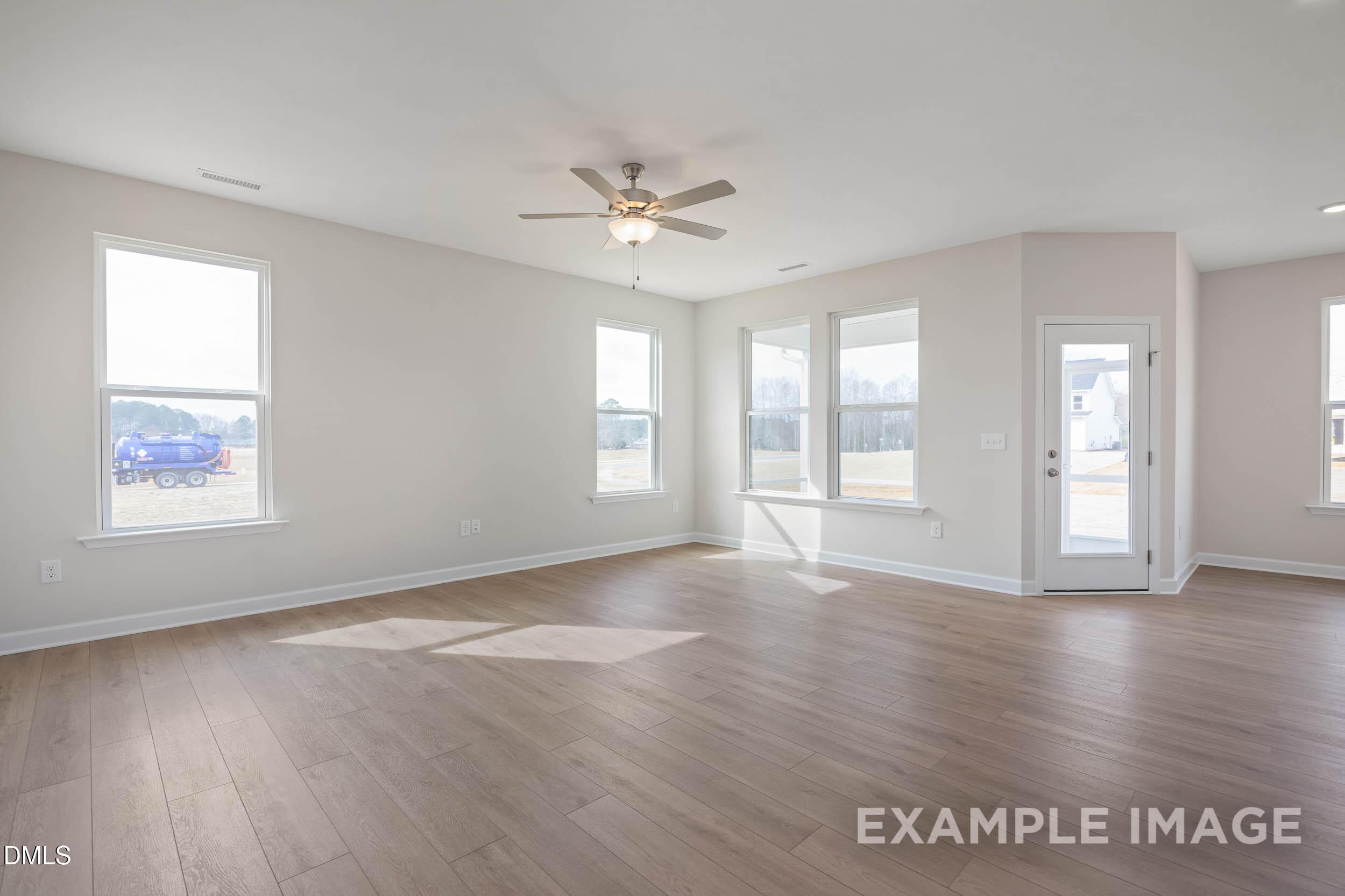 Bright, open-concept living area with wood-style flooring in The Franklin C floor plan at Retreat at North Main.