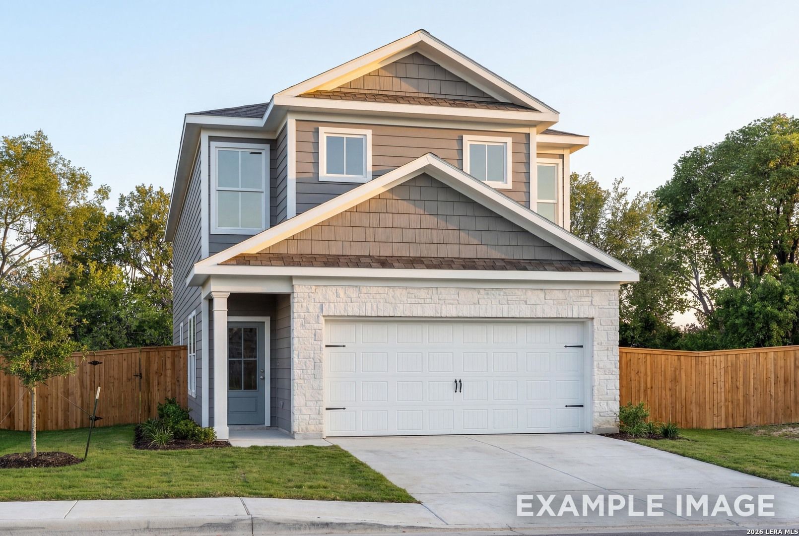 Two-story Charlotte B home by Davidson Homes in Meadows at Oak Creek, San Antonio, Texas: gray siding, stone garage, front porch, lush landscaping
