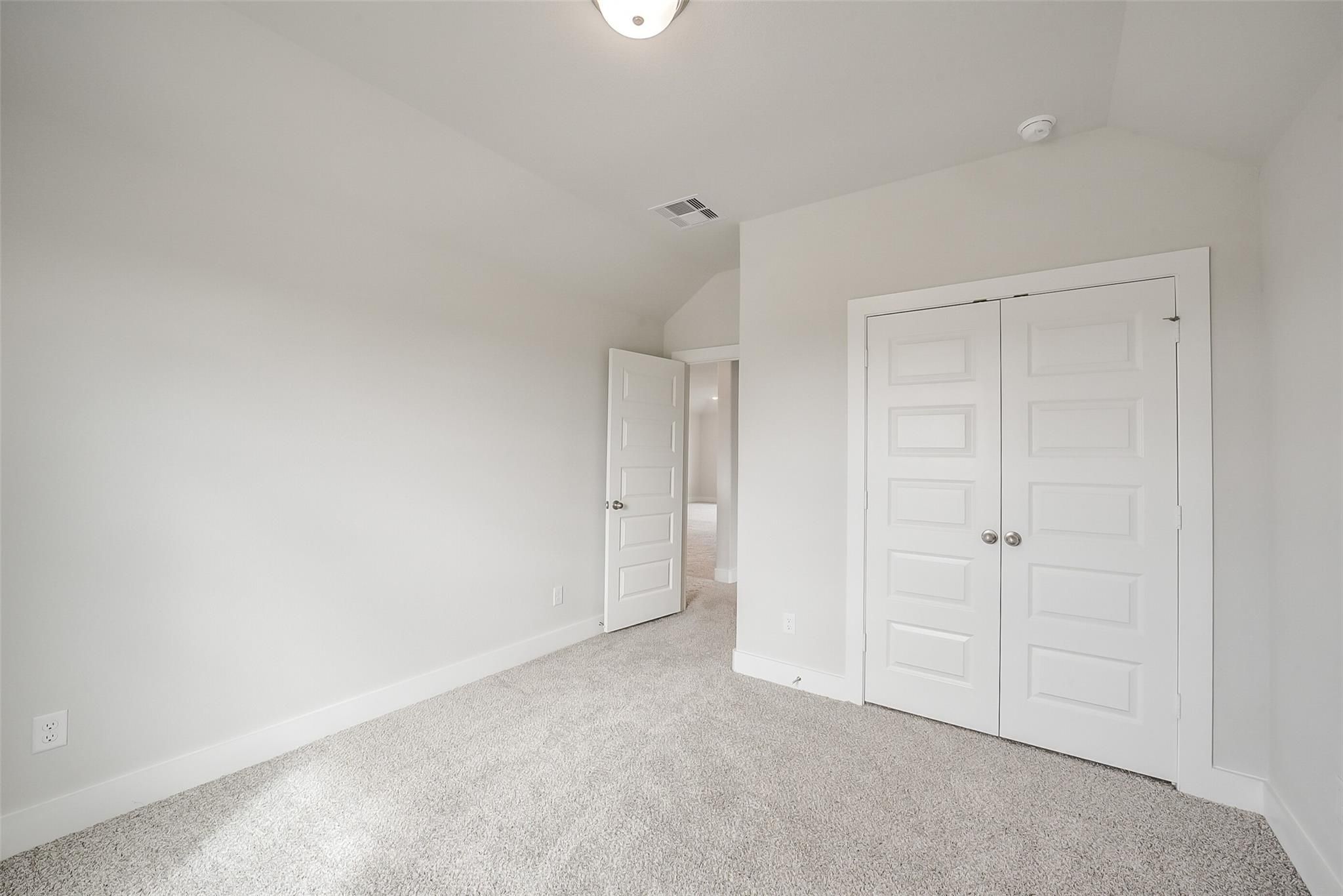 Spacious secondary bedroom with double closet doors and adjacent bath in Davidson Homes The Philip B, Rosharon, Texas