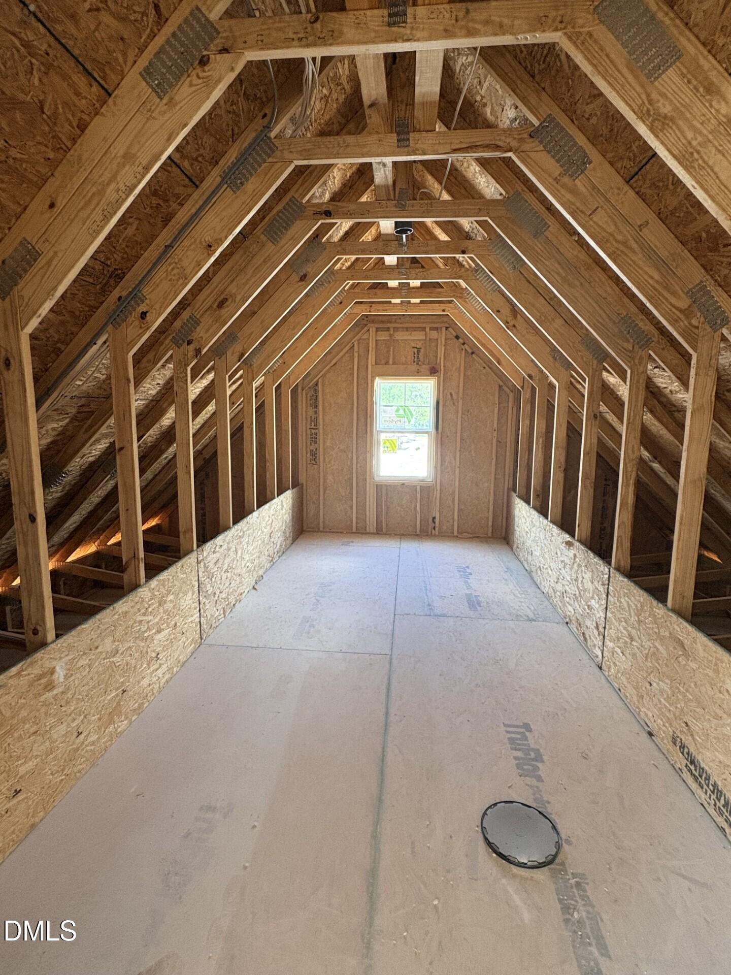 Unfinished attic space with exposed wood framing in The Ash C floor plan at Woodland Crossing, Zebulon, North Carolina.