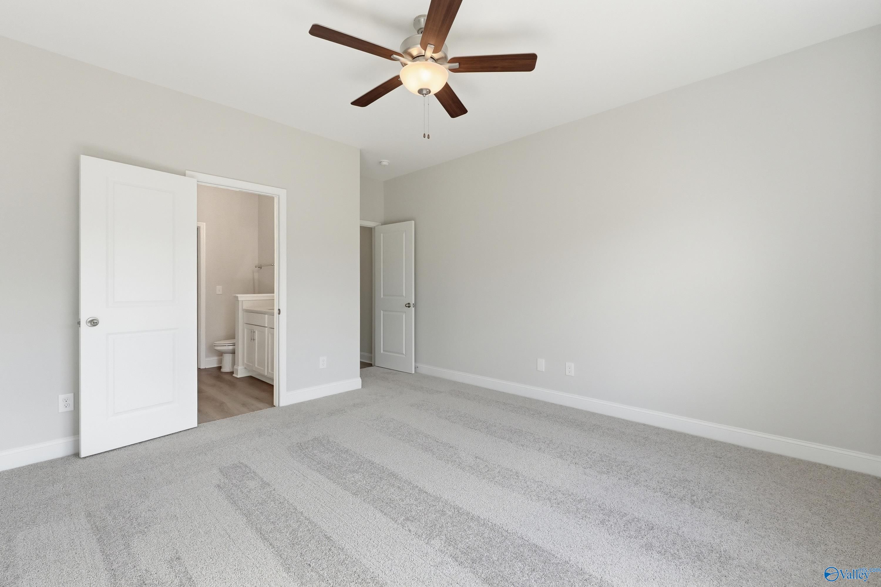 Spacious bedroom with ceiling fan and open en-suite bathroom in Davidson Homes The Asheville C, Huntsville, Alabama