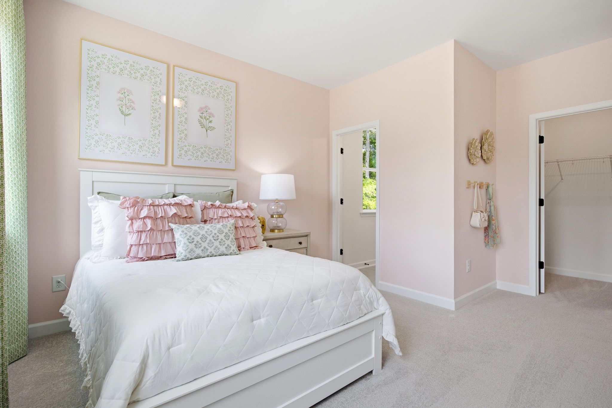 Blush pink girls bedroom at Sage on North Main in Wake Forest NC with white ruffled bed, floral art and green curtains