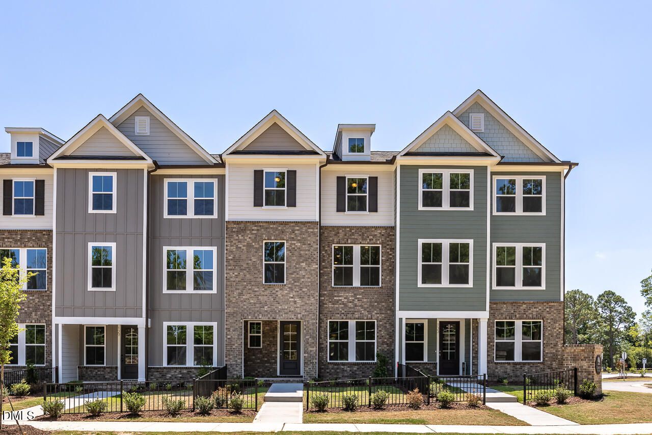 Three-story townhome exterior with brick and siding facade in Camden Park, Knightdale, NC by Davidson Homes.