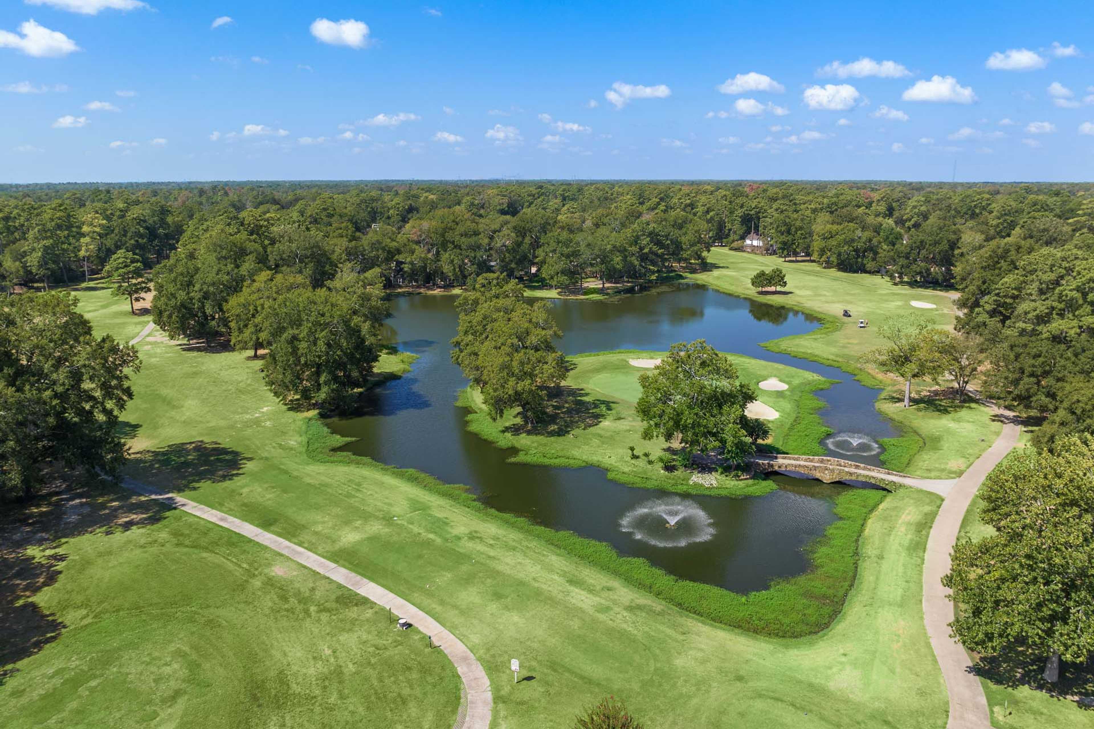 Aerial view of lush golf course at Enclave at Newport in Crosby Texas with fairways lakes fountains and tree-lined paths