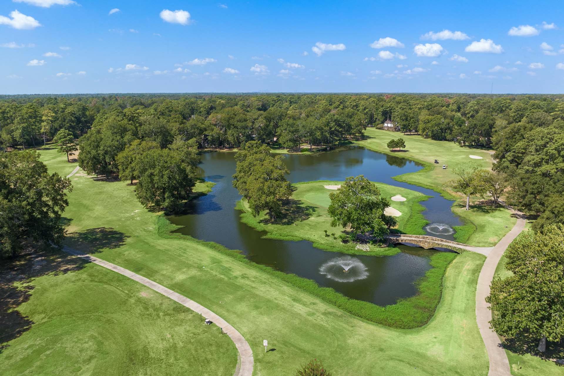 Aerial view of lush golf course at Enclave at Newport in Crosby Texas with fairways lakes fountains and tree-lined paths