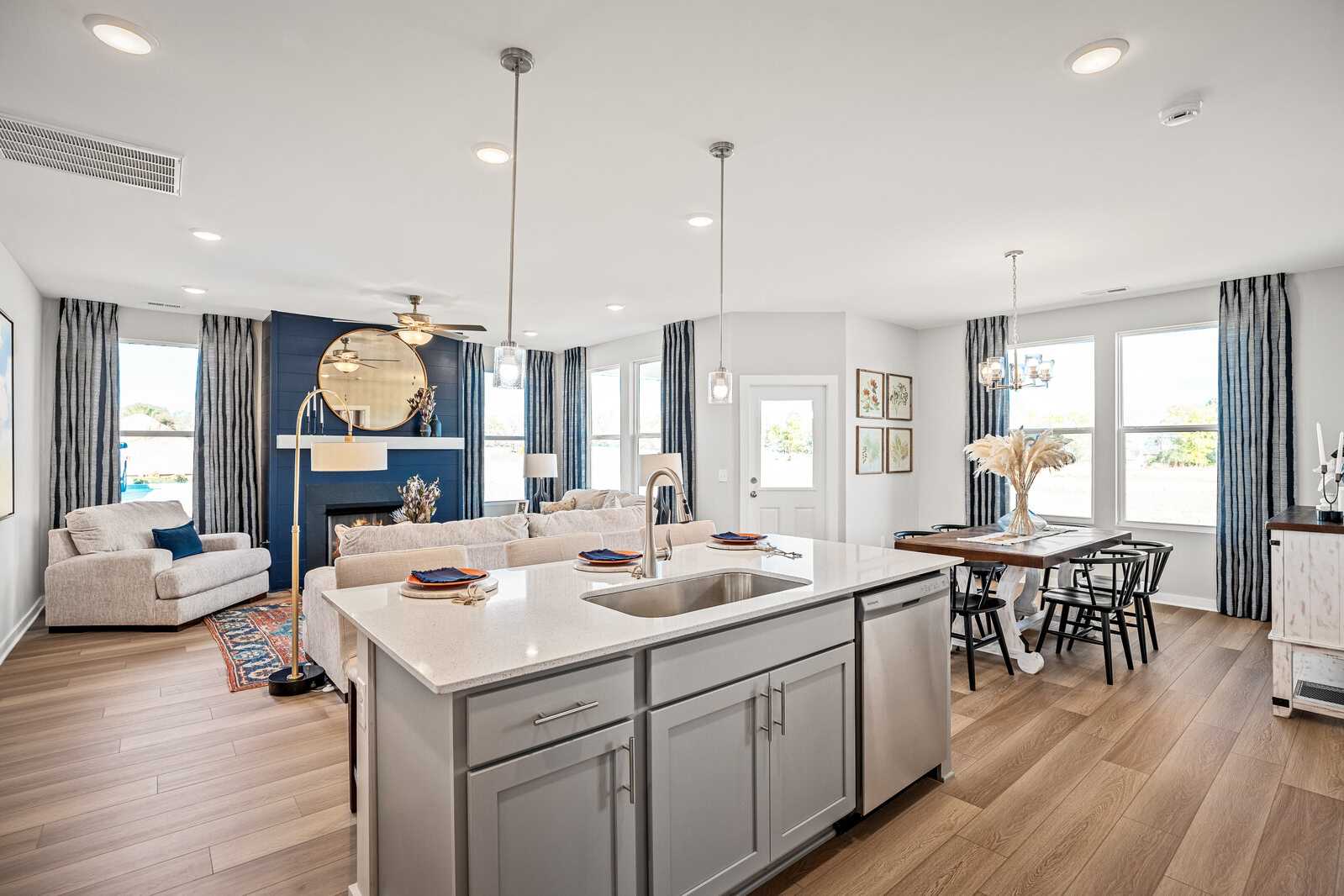 Open-concept kitchen living room at Sage Farms White House TN with quartz island gas fireplace hardwood floors large windows
