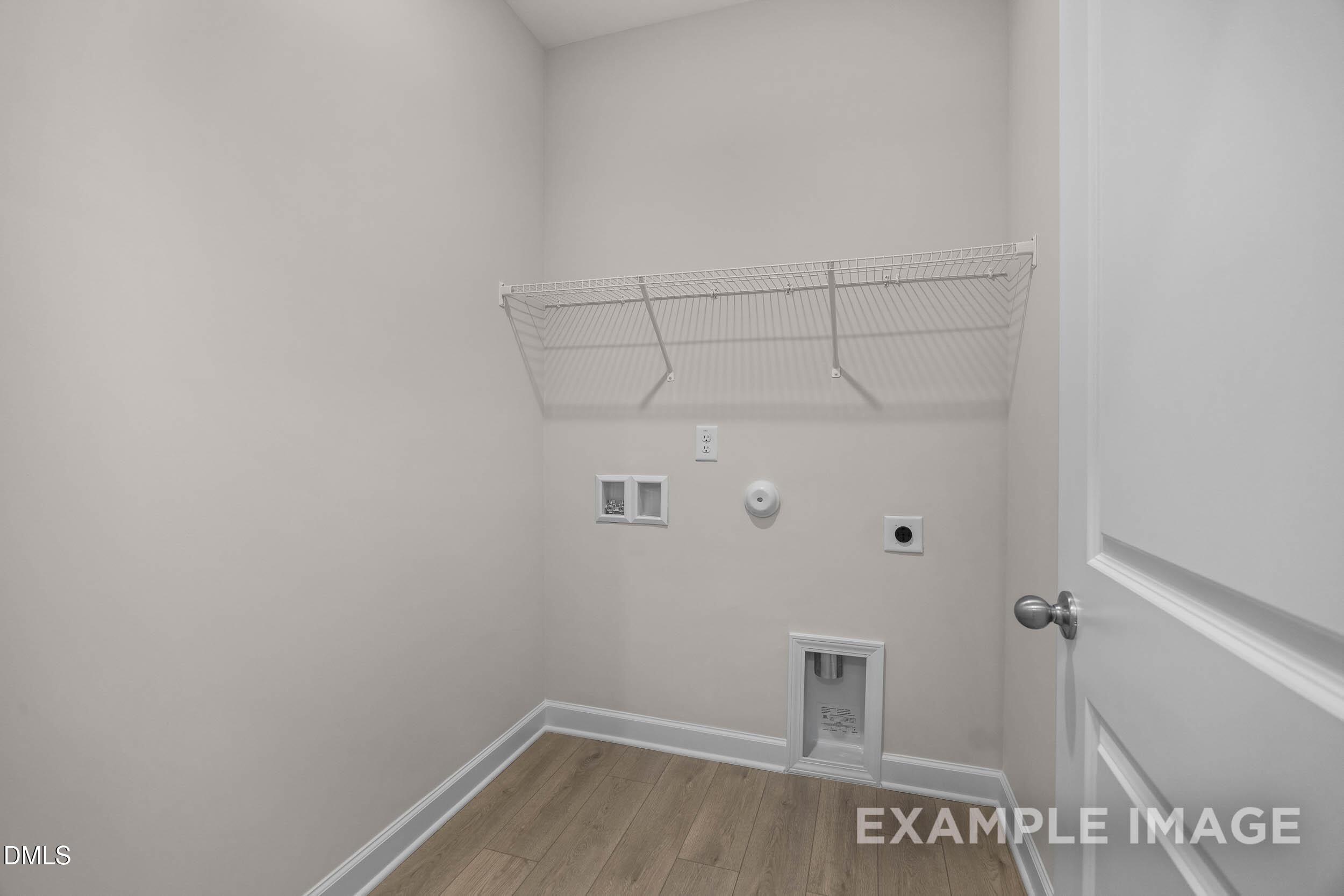 Laundry room with wire shelving and utility hookups in The Franklin C floor plan at Retreat at North Main in Lillington.