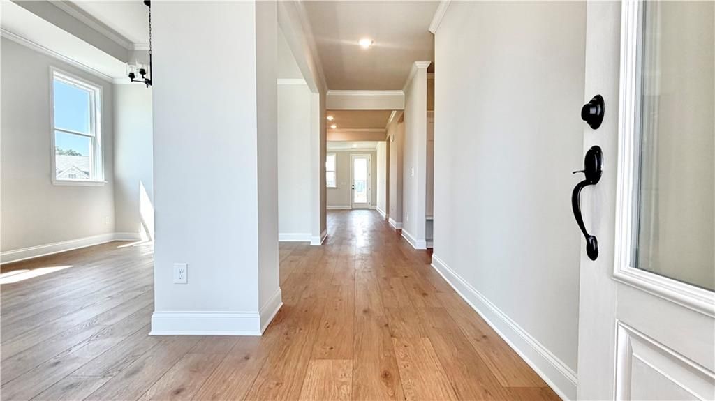 Bright foyer entryway with hardwood floors in The Glenwood A floor plan at Wehunt Meadows in Hoschton, Georgia.