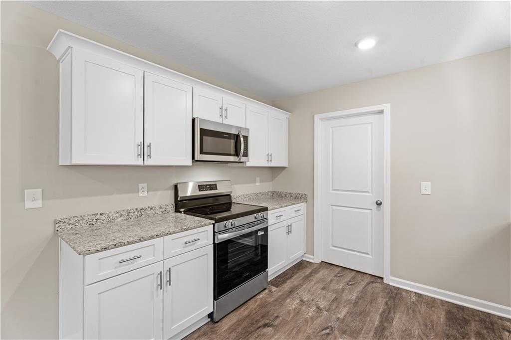 Modern kitchen featuring white shaker cabinets, granite countertops, stainless steel appliances in Davidson Homes The Washington, Phenix City, AL