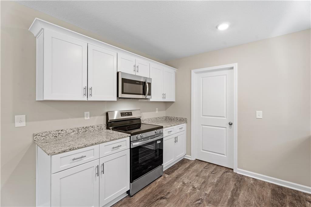 Modern kitchen featuring white shaker cabinets, granite countertops, stainless steel appliances in Davidson Homes The Washington, Phenix City, AL