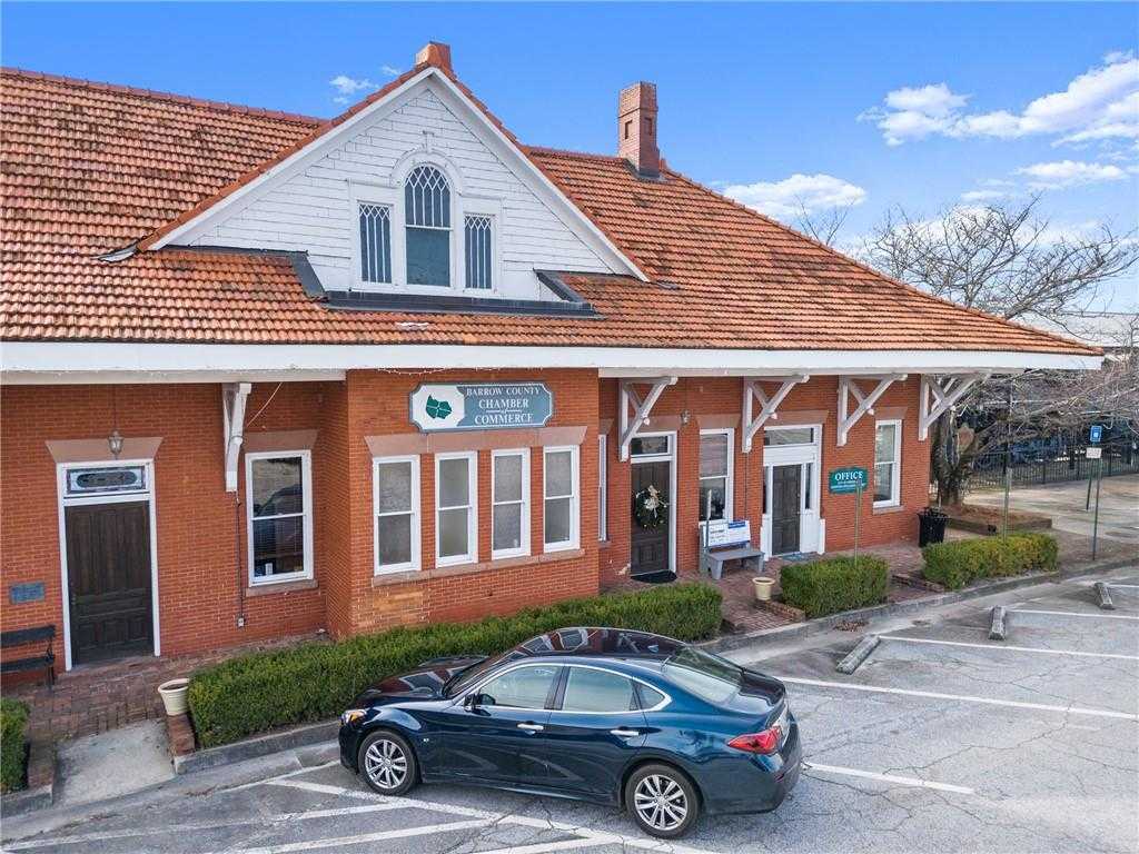 Historic red brick Davidson Homes office with terracotta roof, white trim, and parked blue sedan in Lake Shore, Winder, Georgia