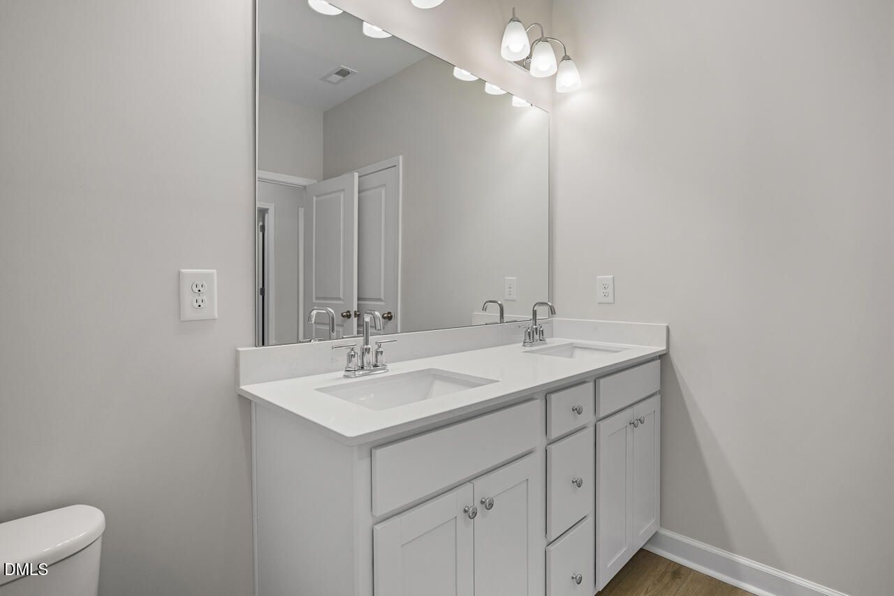 Modern bathroom vanity with double sinks and large mirror in The Chestnut floor plan by Davidson Homes in Aberdeen, NC.