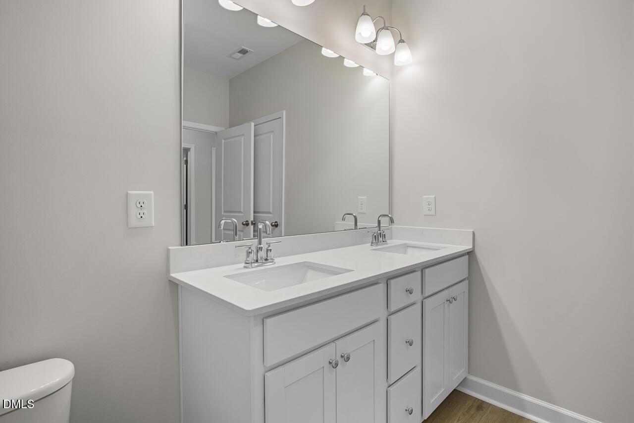 Modern bathroom vanity with double sinks and large mirror in The Chestnut floor plan by Davidson Homes in Aberdeen, NC.