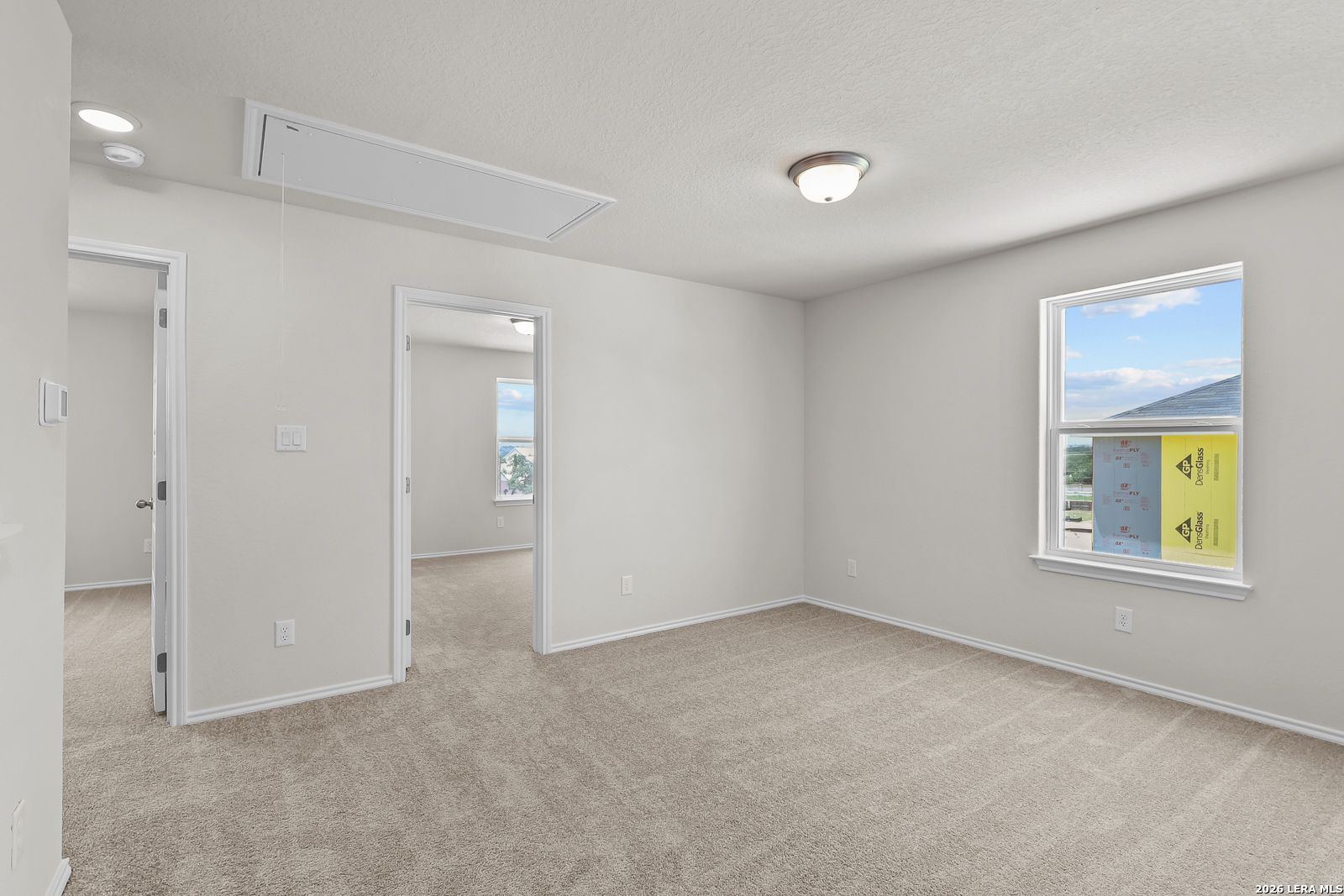 Bright secondary bedroom with plush carpeting in The Gillian B floor plan at Meadows at Oak Creek, San Antonio, Texas.