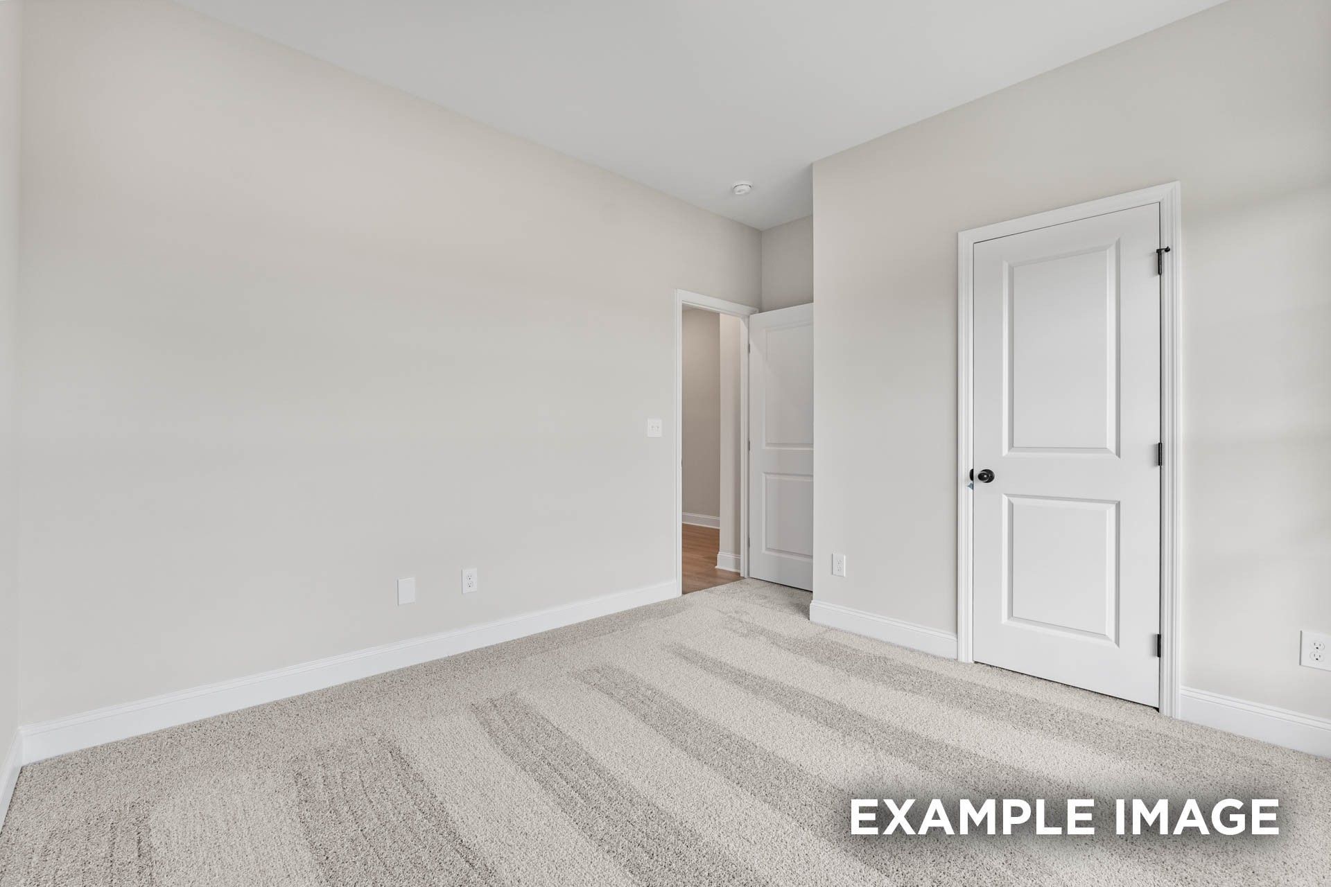 Spacious secondary bedroom with neutral carpet and white doors in The Franklin E floor plan at Bailey Park, Fayetteville.