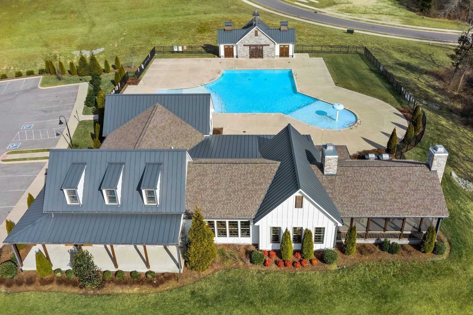 Aerial view of Davidson Homes Ridgeport 4-bedroom house with 2-car garage, community pool, and lush green lawns in Carellton, Gallatin, Tennessee