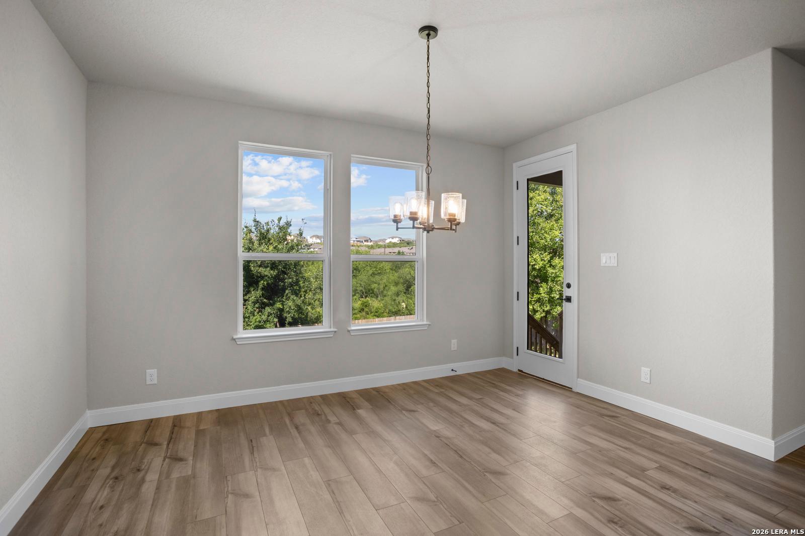 Bright dining area with wood-style flooring and backyard access in The Jennings G floor plan by Davidson Homes in Ladera.