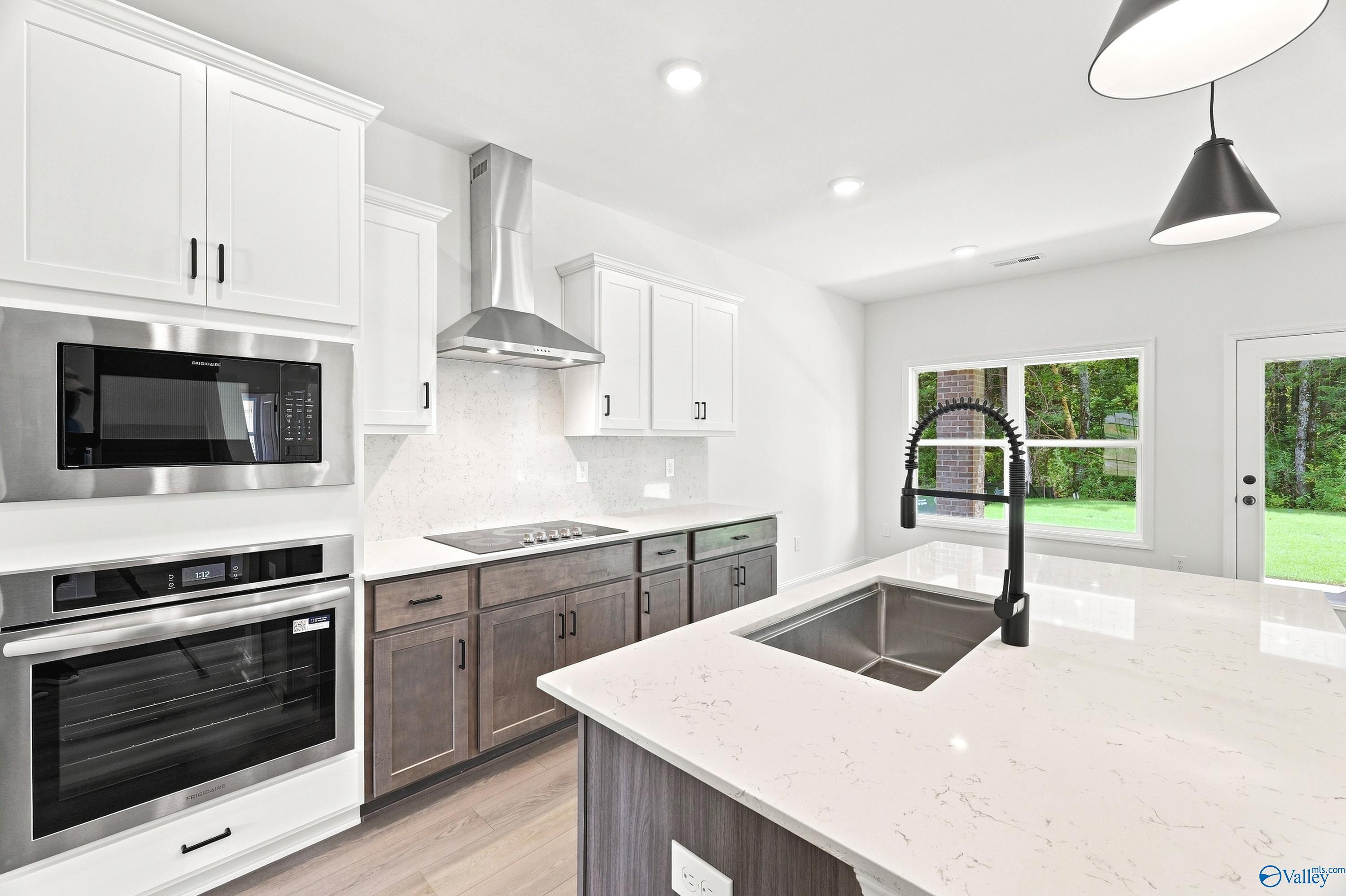 Modern kitchen with quartz countertops and stainless appliances in The Shelby B floor plan at Jaguar Hills, Huntsville, AL.