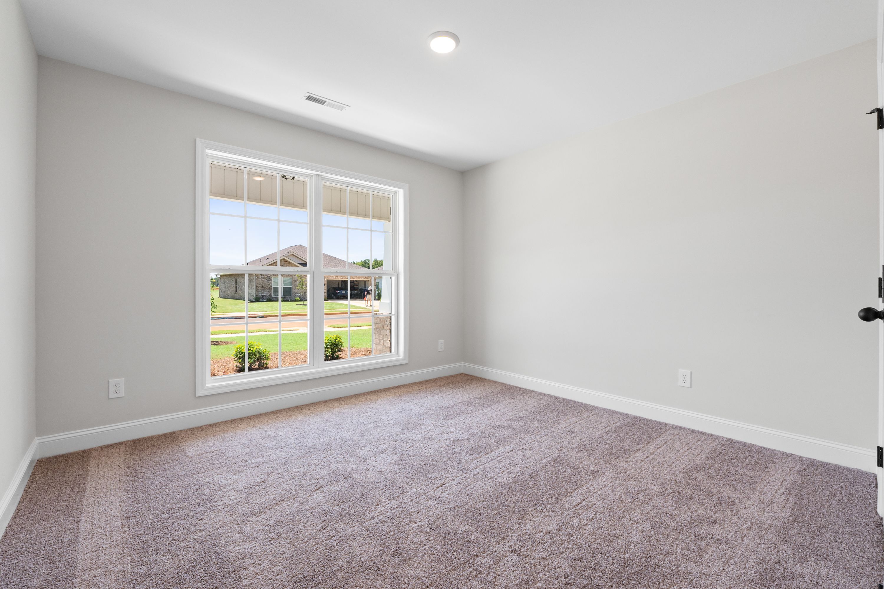 Bright bedroom with neutral walls and plush carpeting in The Holly C floor plan by Davidson Homes.