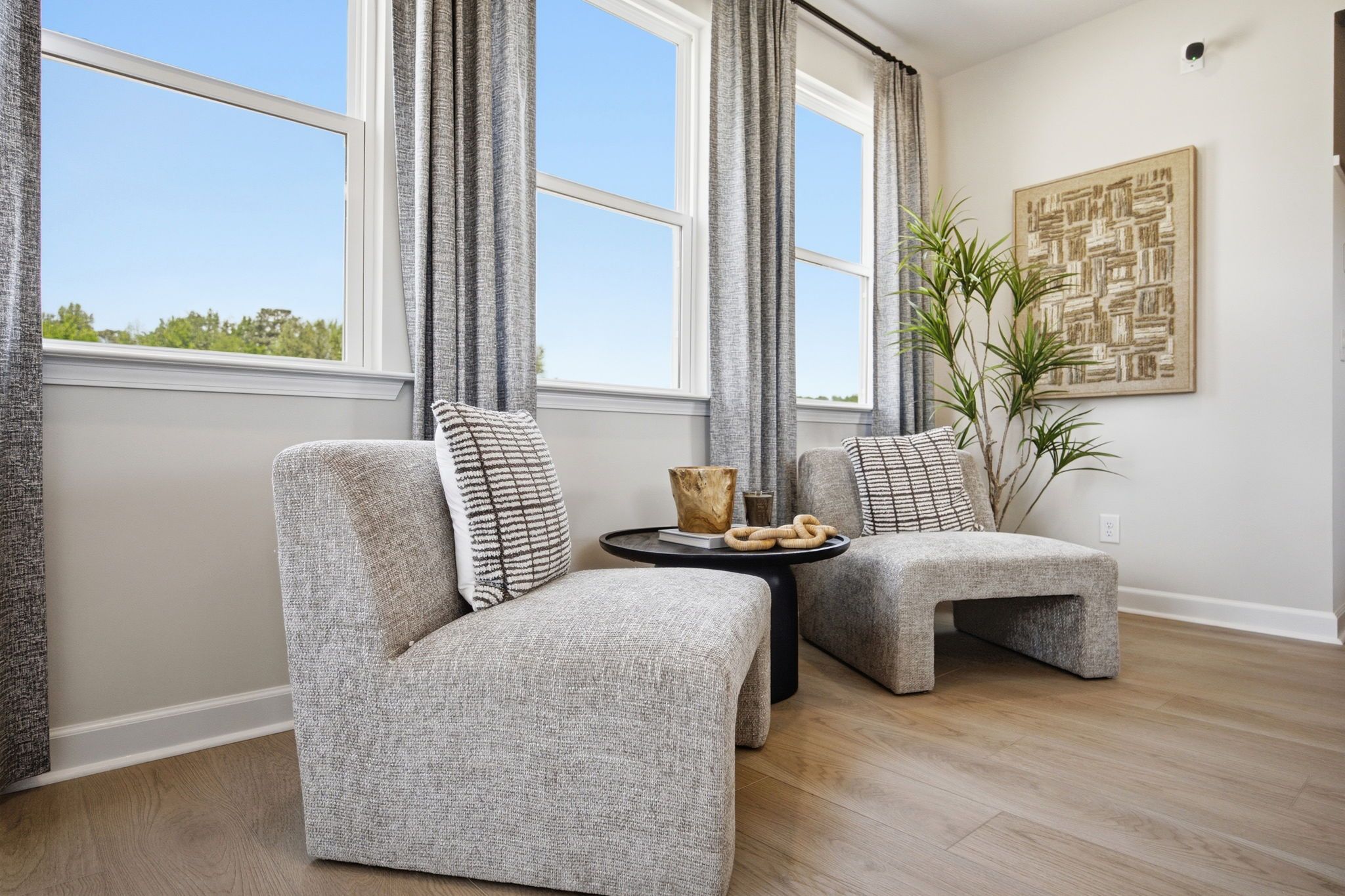 Cozy seating area in The Burke C home design featuring modern armchairs, natural light, and elegant interior styling.