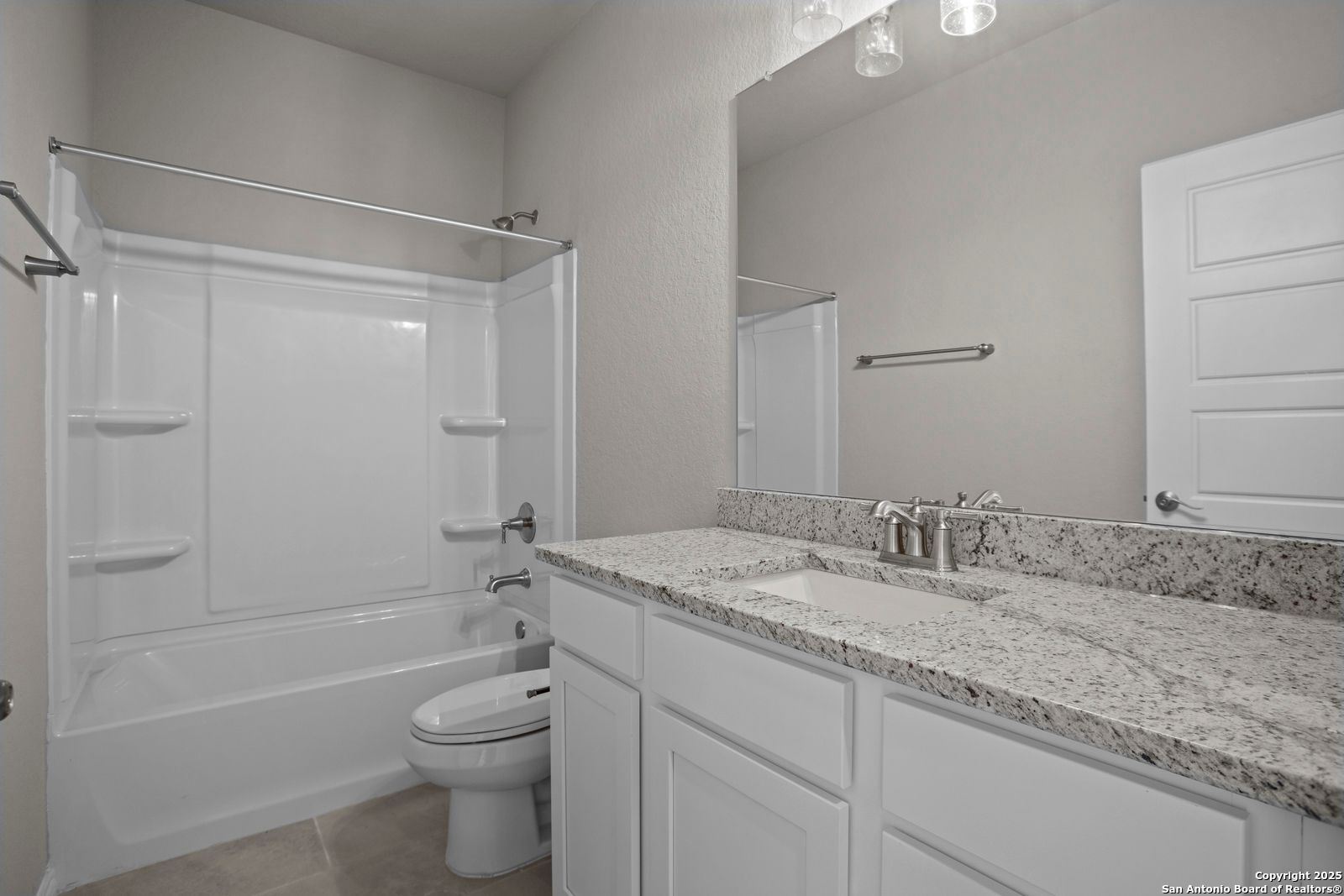 Modern guest bathroom with granite vanity, tub-shower combo, and neutral walls in Davidson Homes The Collin B, Seguin, Texas