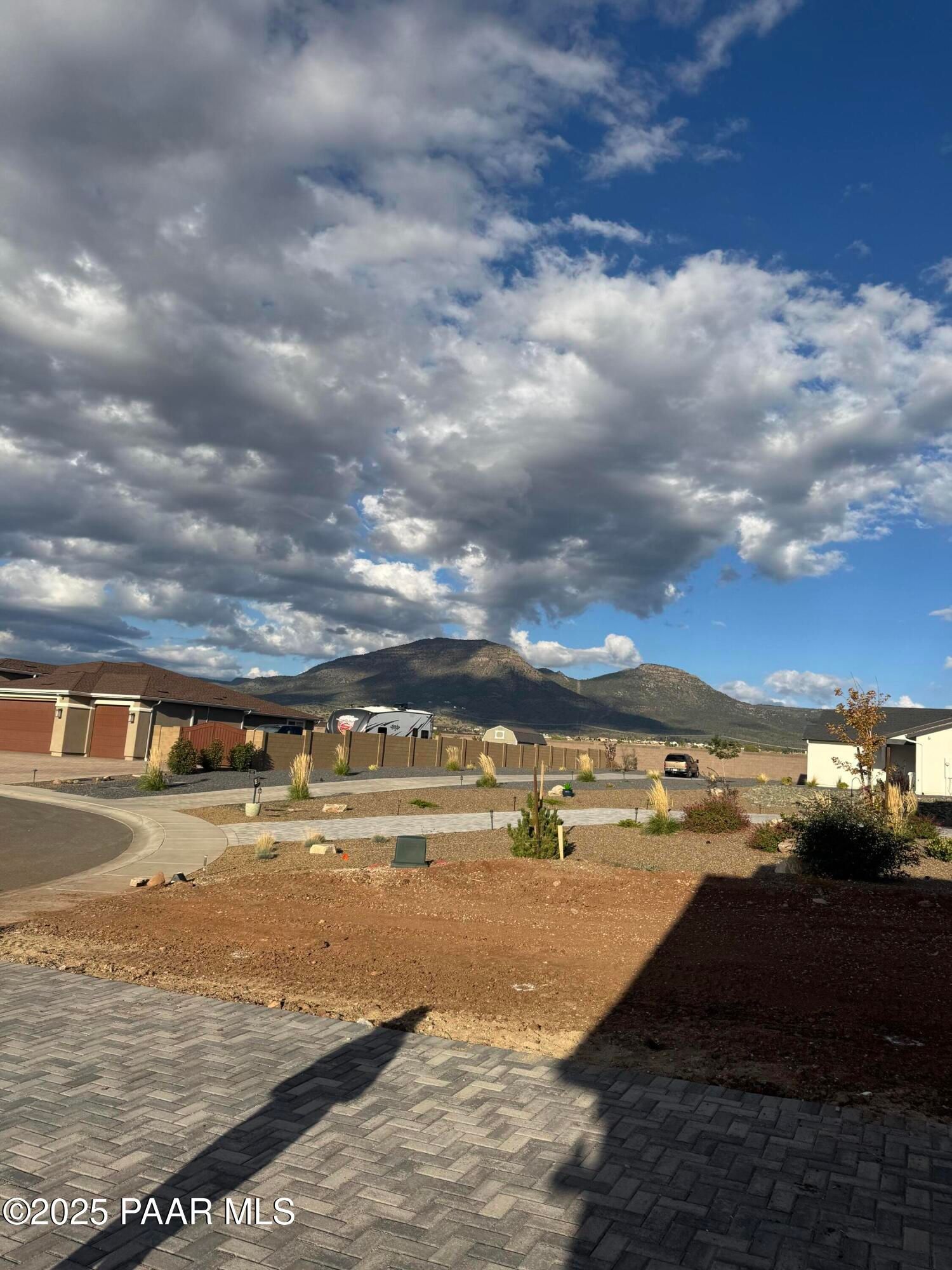 Stunning mountain backdrop with cloudy skies behind modern single-story homes in Morningstar, Prescott Valley, Arizona