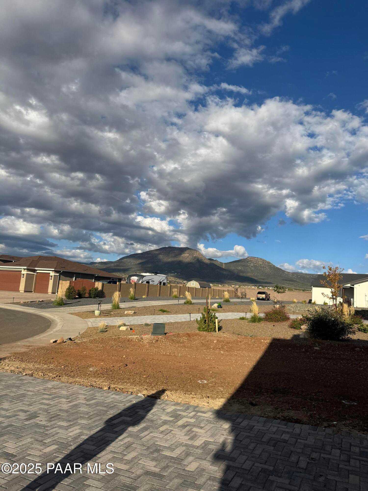 Stunning mountain backdrop with cloudy skies behind modern single-story homes in Morningstar, Prescott Valley, Arizona