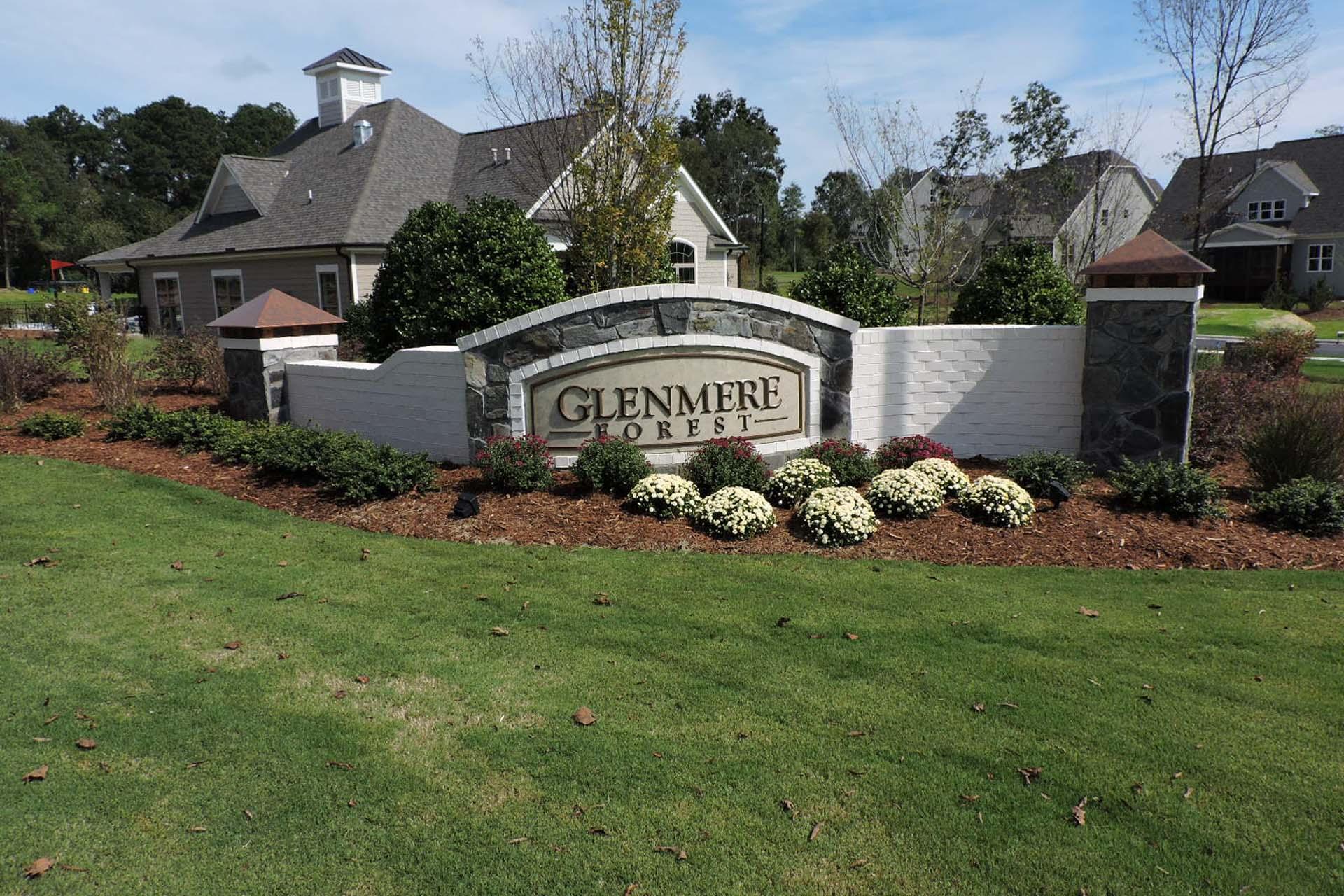 Glenmere entrance sign at Davidson Homes community in Knightdale NC with stone archway, white flowers, and lush landscaping
