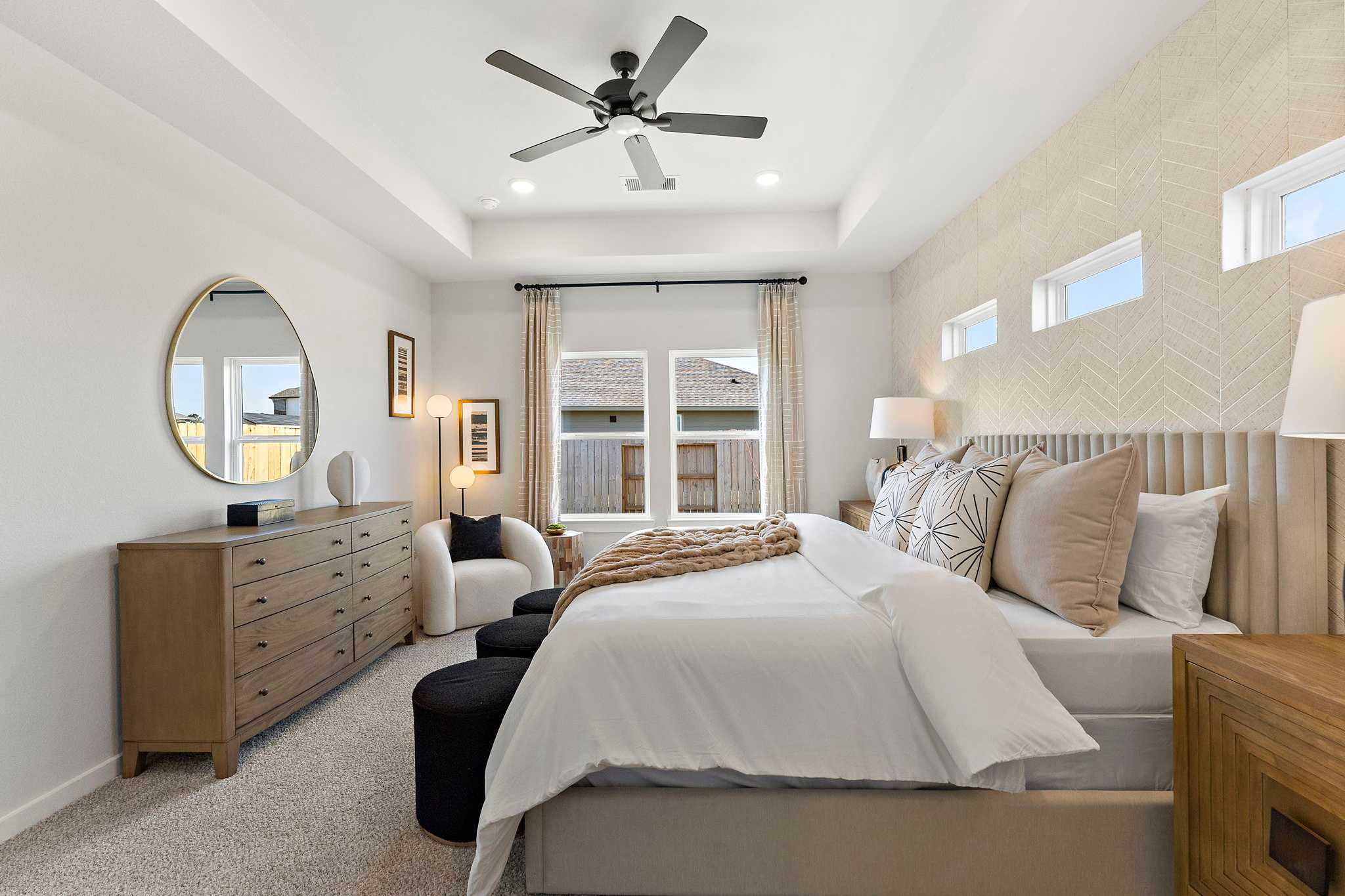 Spacious master bedroom at Sundance Cove in Crosby TX by Davidson Homes with king bed, tufted headboard, wooden dresser