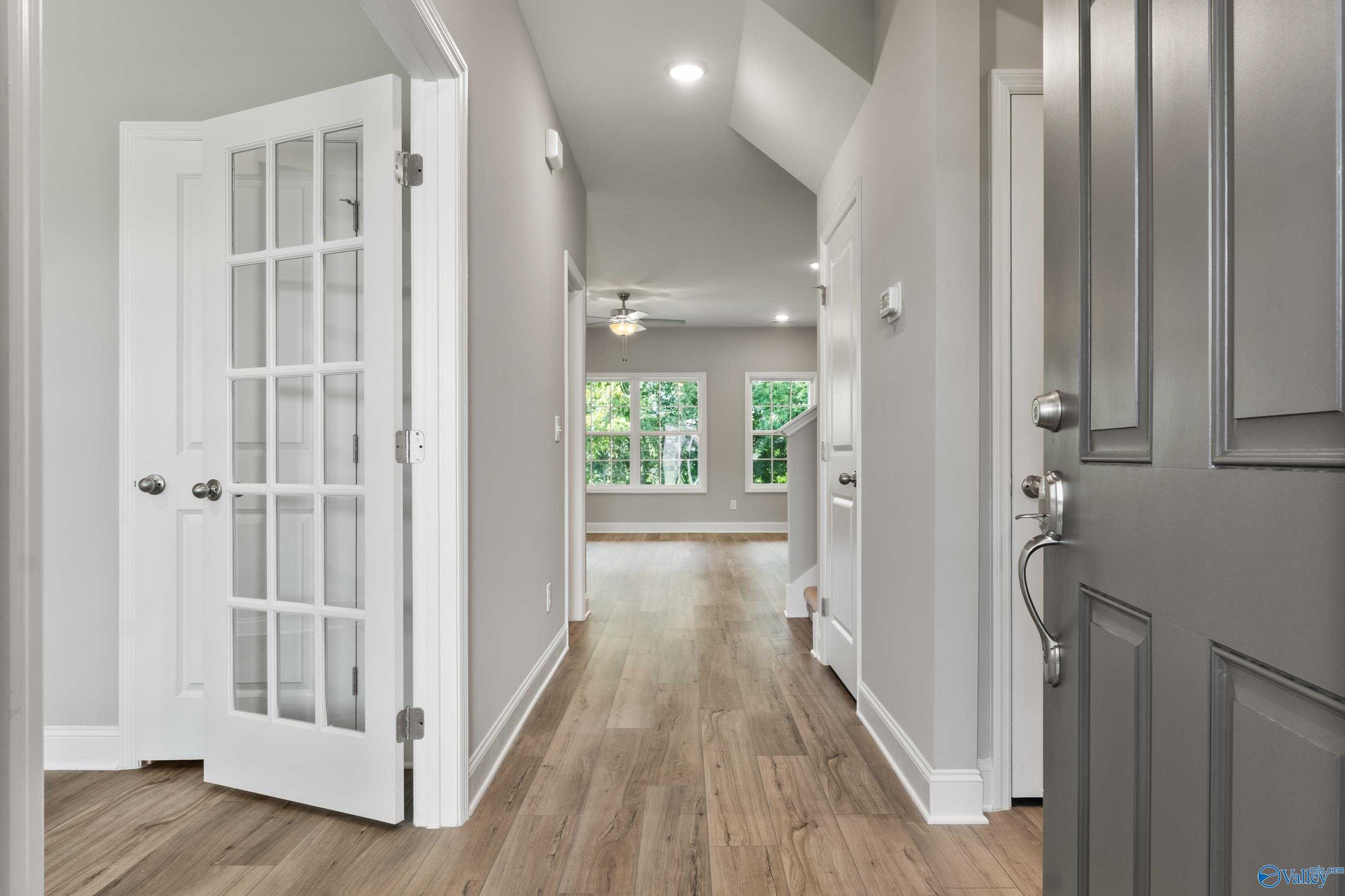 Bright entry hallway with hardwood floors, glass doors, and window views in Davidson Homes The Rockford, Creekside, Harvest AL