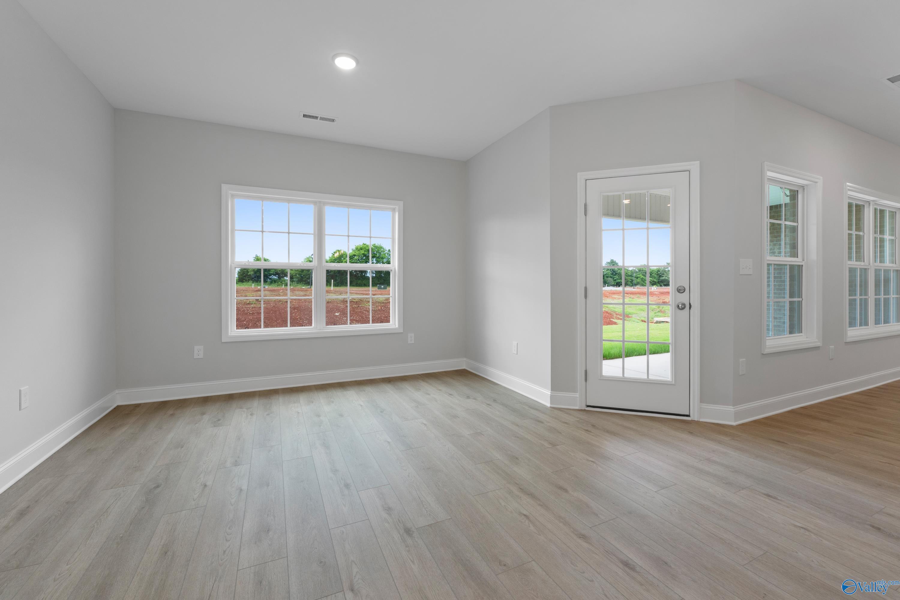 Bright family room with large windows, sliding glass door to lush backyard in Davidson Homes The Rockford B, Toney, AL