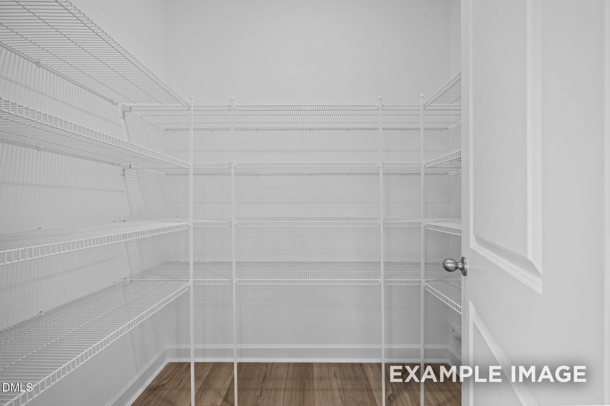 Spacious walk-in closet featuring white wire shelving in Davidson Homes The Avery floor plan, Knightdale, North Carolina