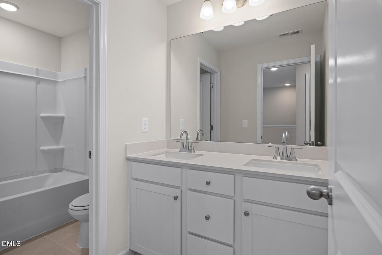 Modern double vanity bathroom with tub shower combo in The Mitchell Interior floor plan at Camden Park, Knightdale, NC.