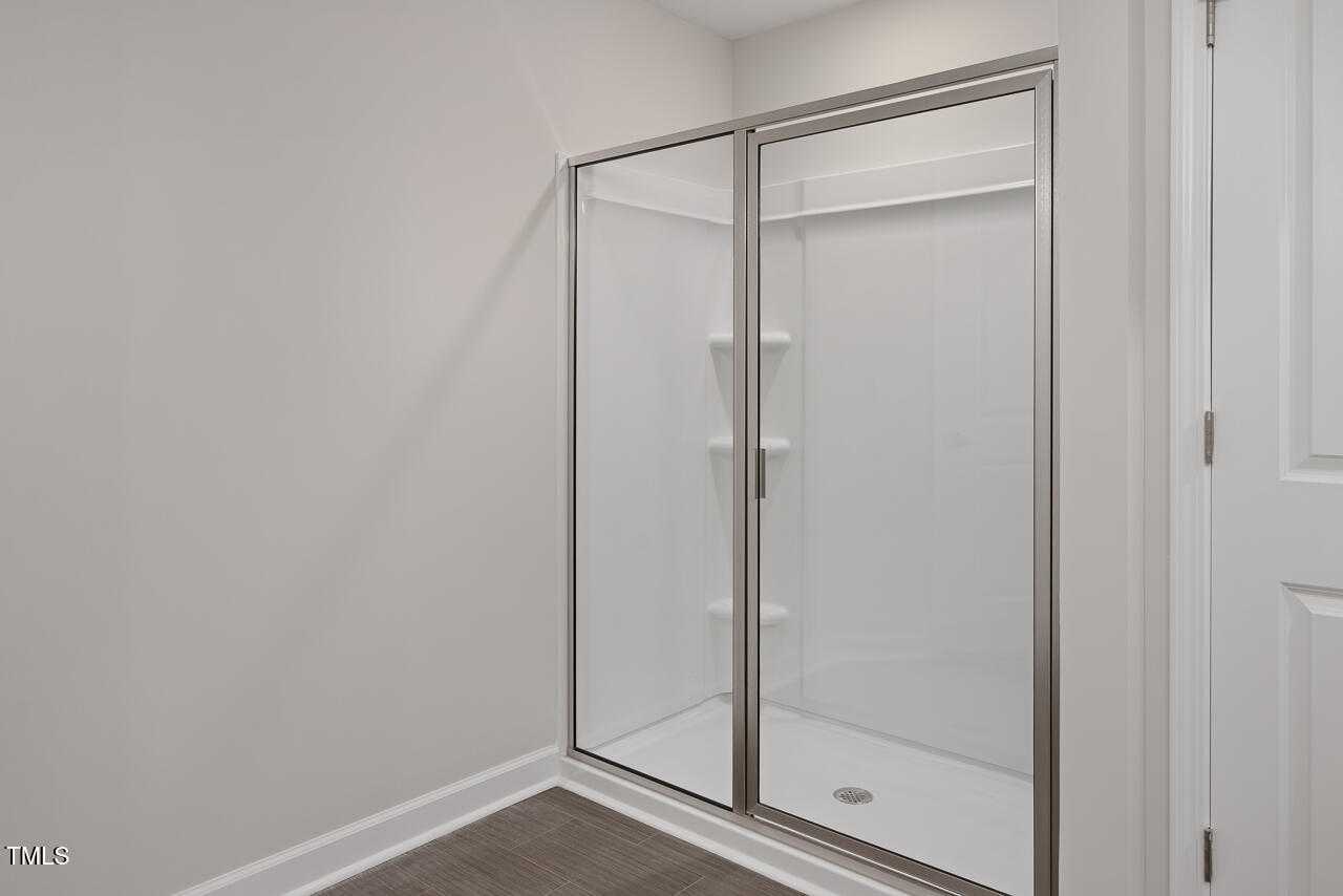 Frameless glass walk-in shower with built-in shelves in master bathroom of Davidson Homes The Graham, Fuquay-Varina, NC