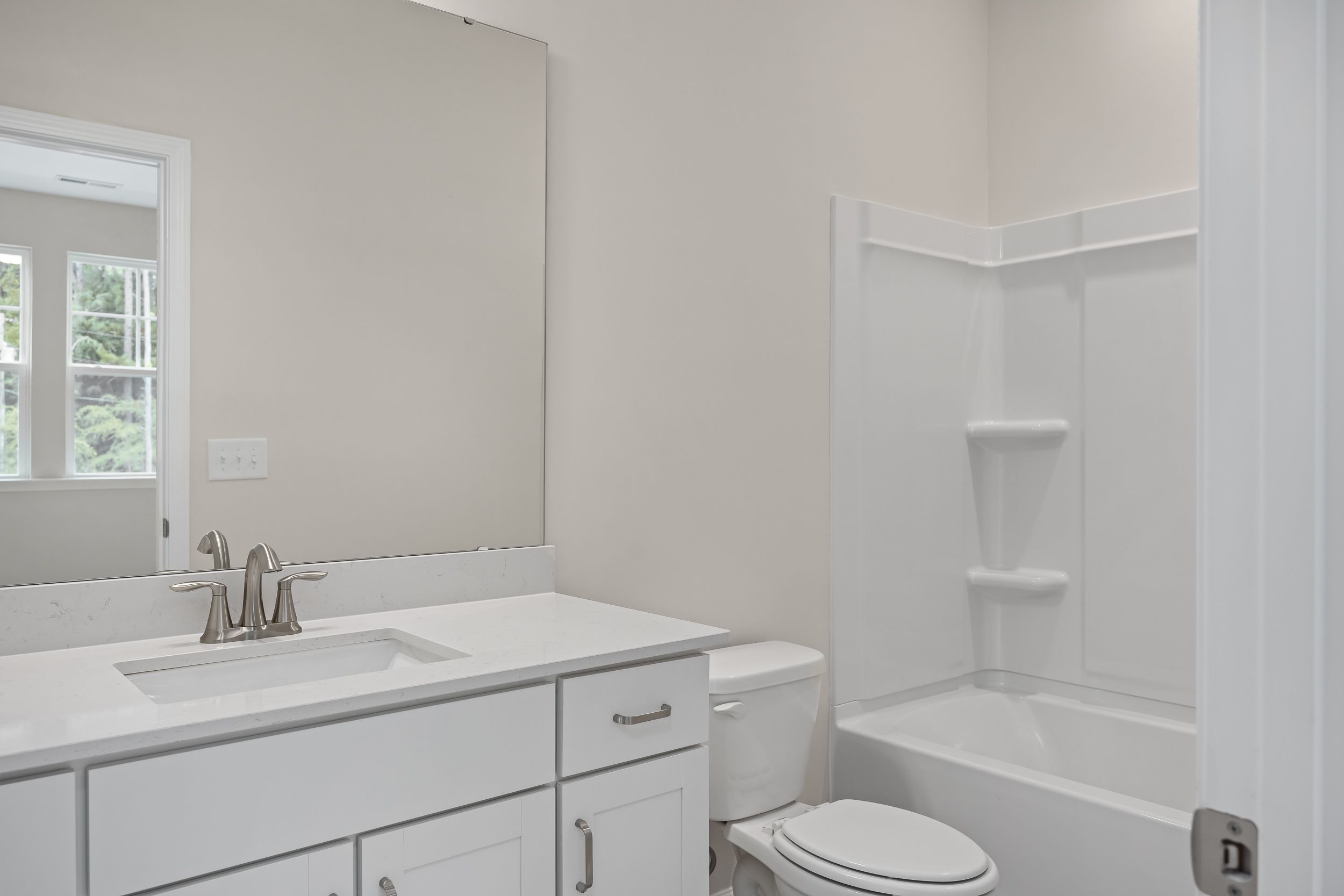 Spacious master bathroom in The Beech A with white vanity, soaking tub, walk-in shower, and neutral walls