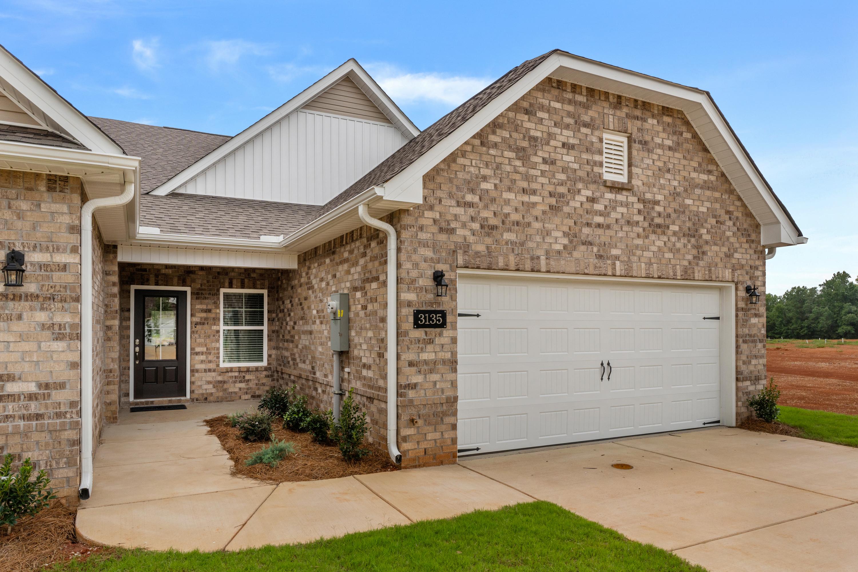 Brick home exterior at The Retreat at Hollon Meadow in Decatur Alabama with garage driveway and landscaping