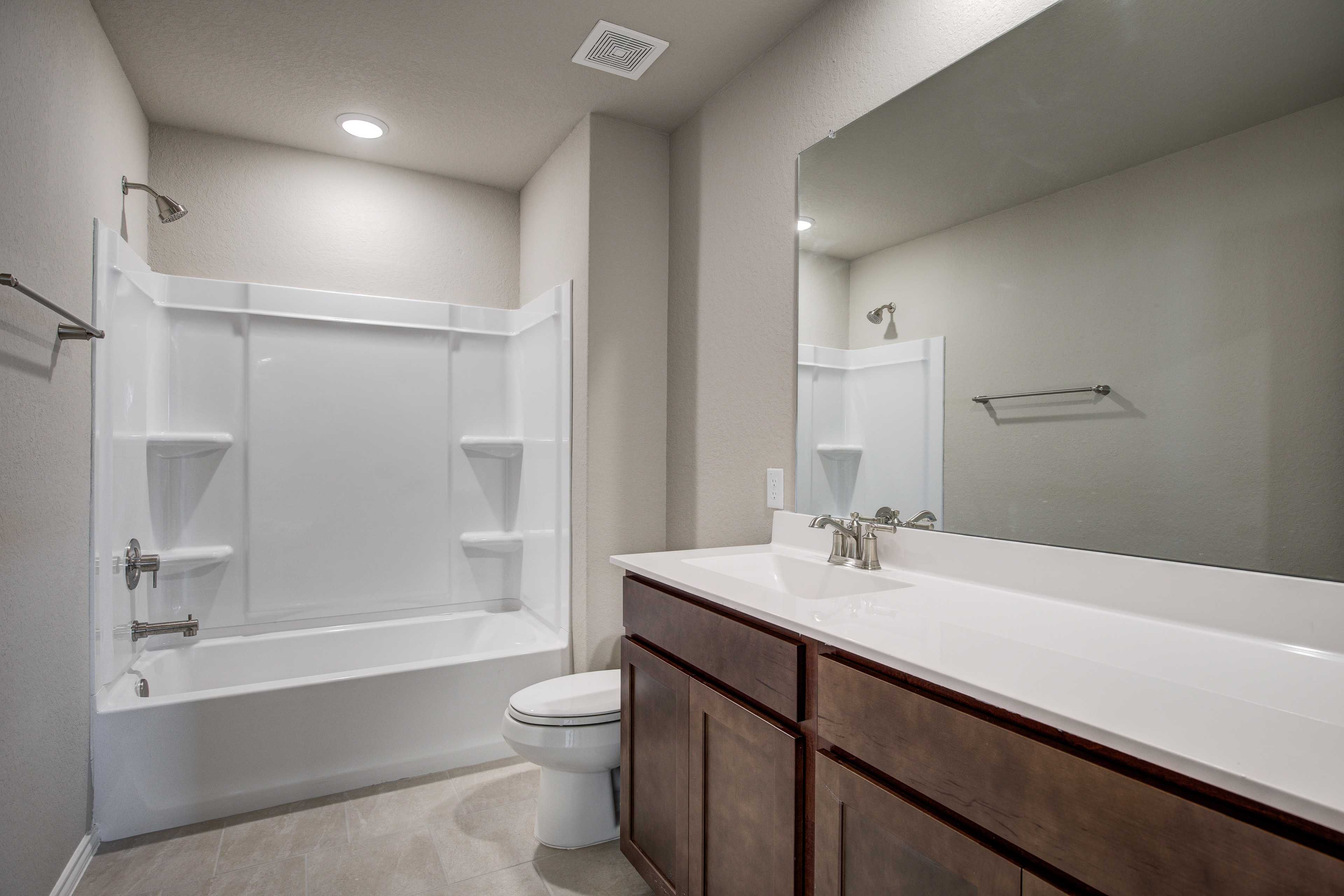 Spacious master bathroom in The Murray by Davidson Homes: white tub, glass shower, double vanity with shaker cabinets