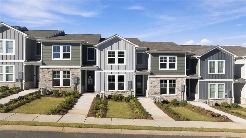 Modern townhome exteriors with stone accents and landscaped front yards at Stegall Village, Emerson, Georgia by Davidson Homes