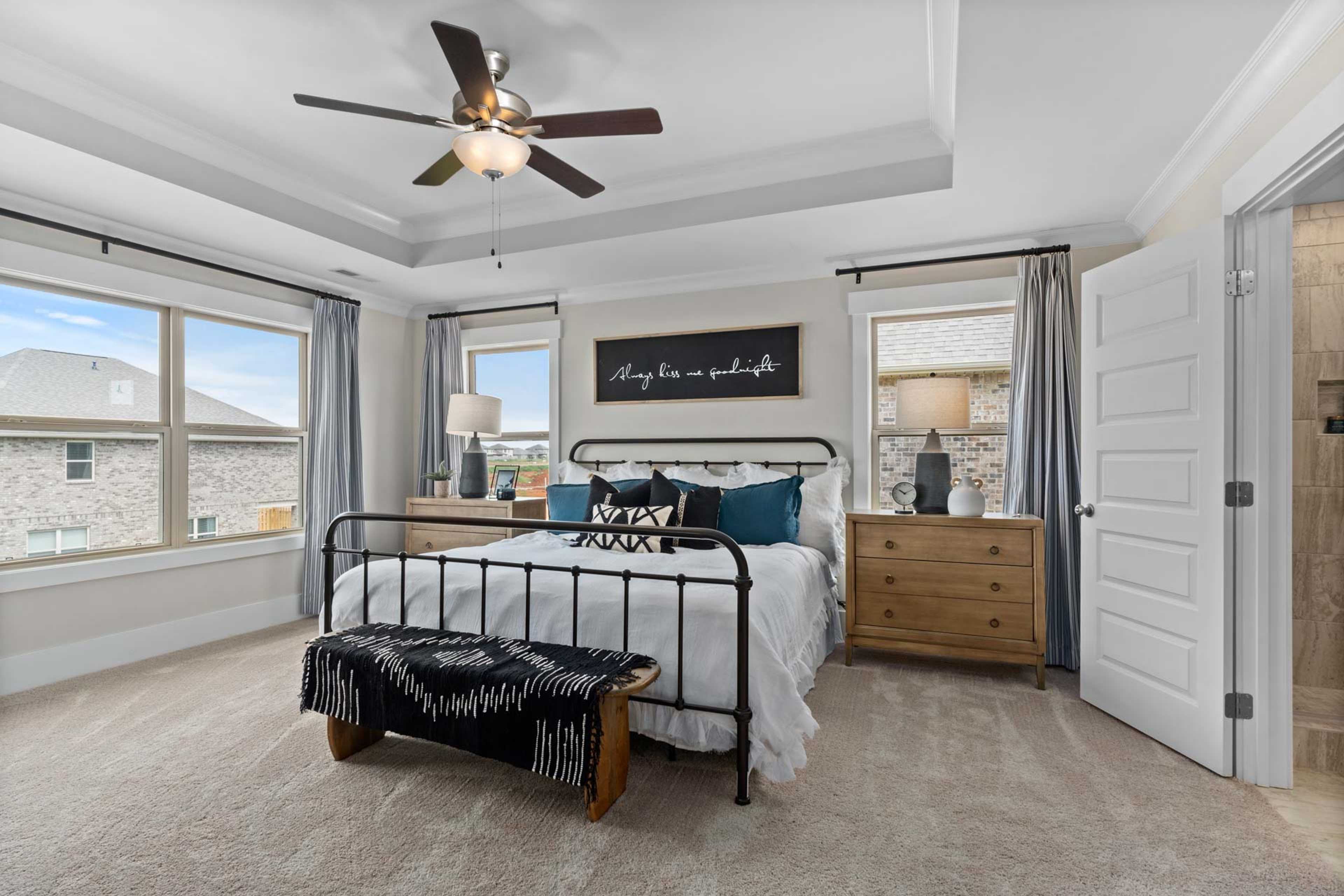 Spacious master bedroom at Walker's Hill in Meridianville, Alabama with king bed, ceiling fan, and large windows