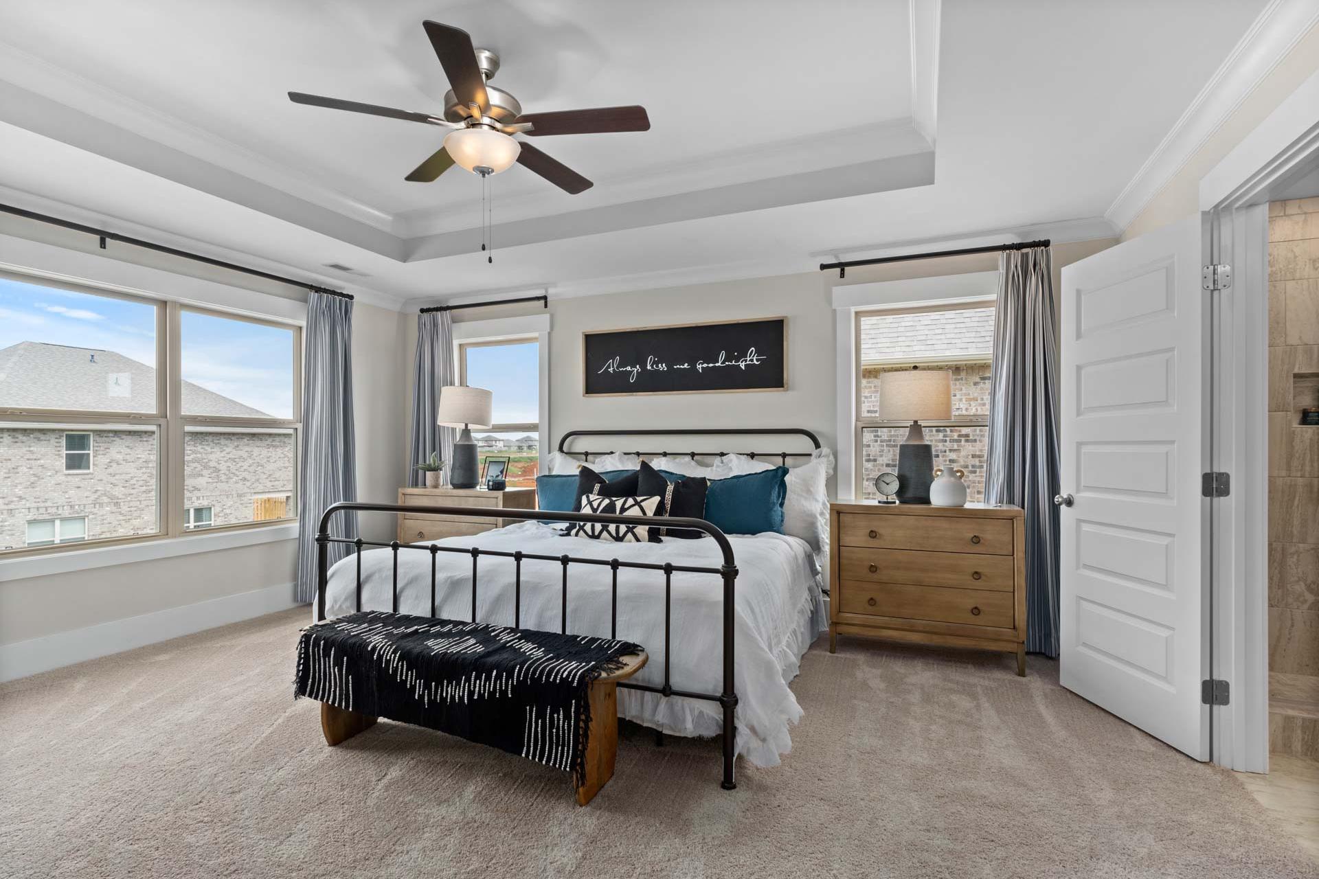 Spacious master bedroom at Walker's Hill in Meridianville, Alabama with king bed, ceiling fan, and large windows