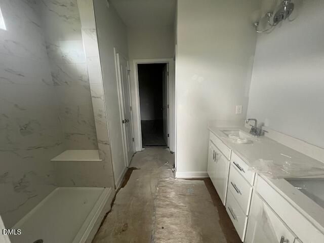 Modern primary bathroom with marble-tiled walk-in shower and dual vanity in The Ash B floor plan at Retreat at North Main.