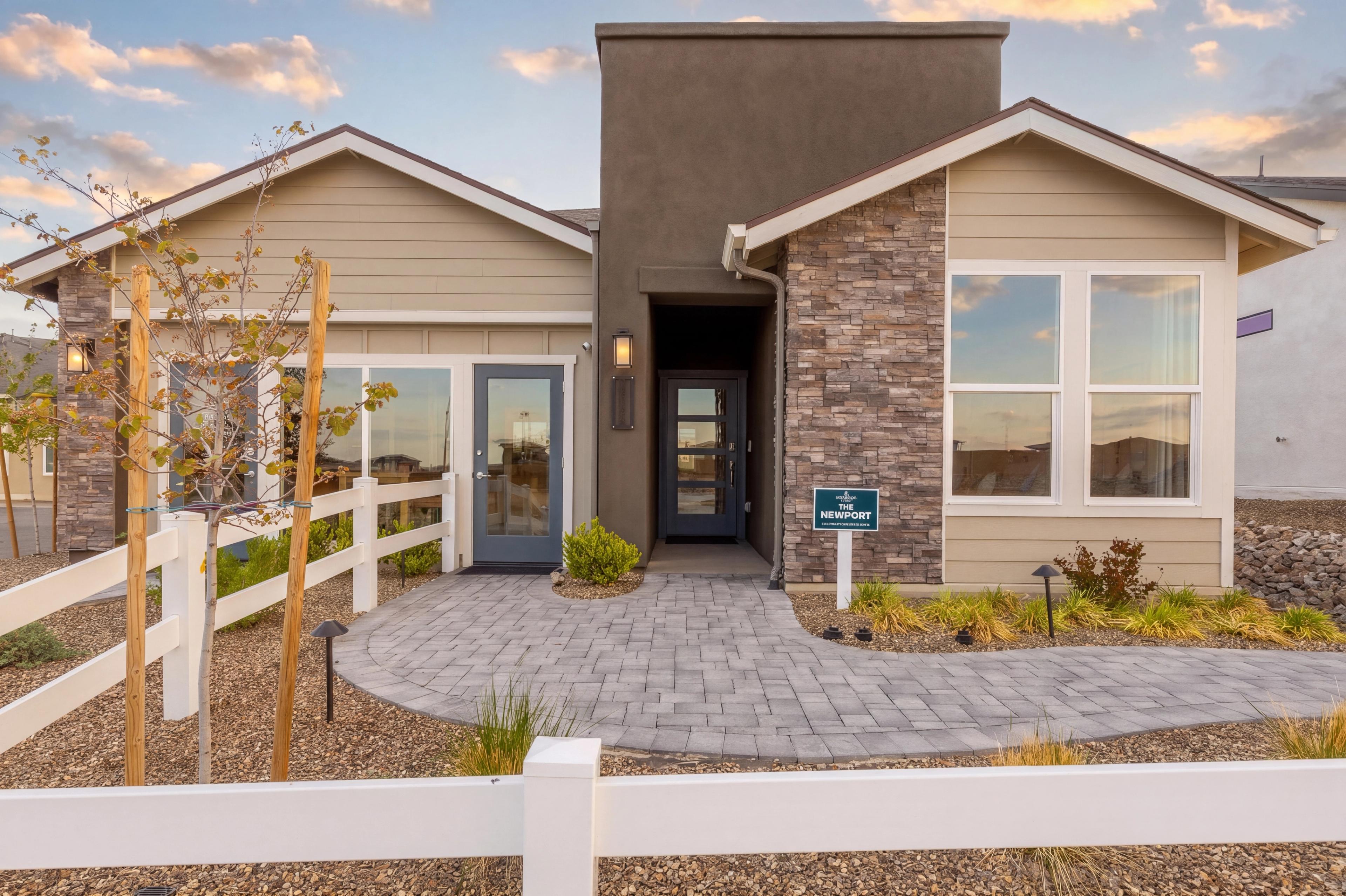 Newport floor plan exterior at South Ranch in Prescott, AZ by Davidson Homes featuring stone accents and a paver walkway.