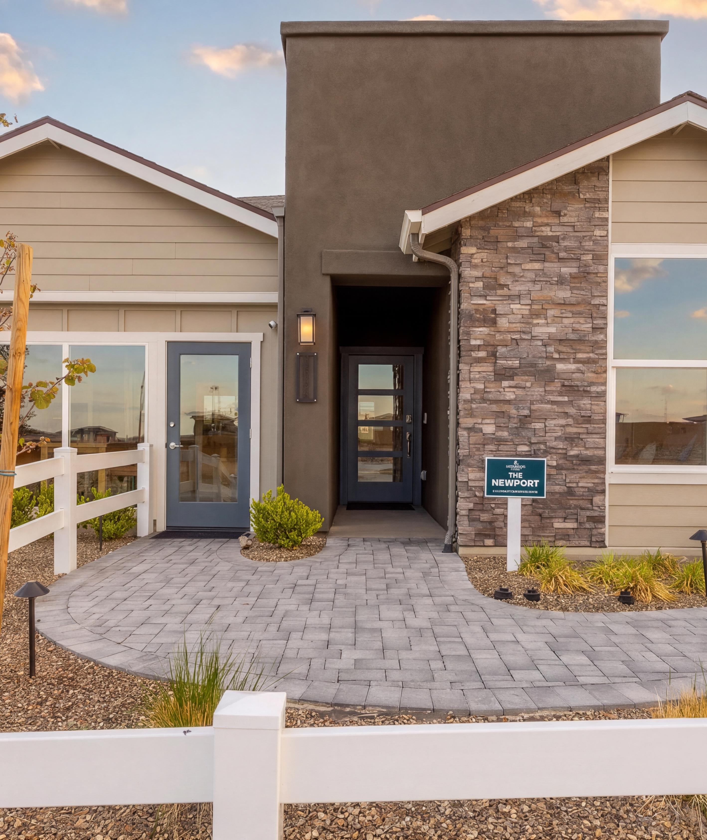 Newport floor plan exterior at South Ranch in Prescott, AZ by Davidson Homes featuring stone accents and a paver walkway.