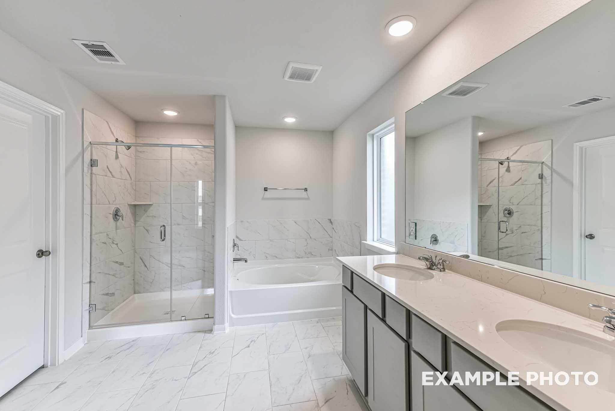 Primary bathroom with glass walk-in shower, soaking tub, and dual vanity in The Costa A floor plan at River Ranch Meadows, Dayton, TX